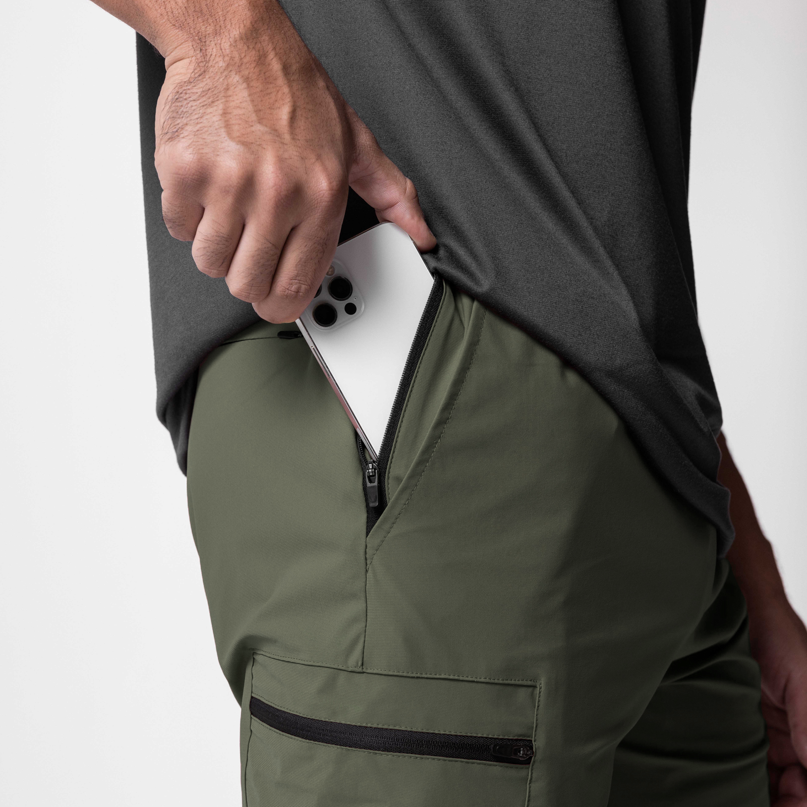 Tetra-Lite Standard Zip Jogger in olive, worn by model holding white phone in pocket