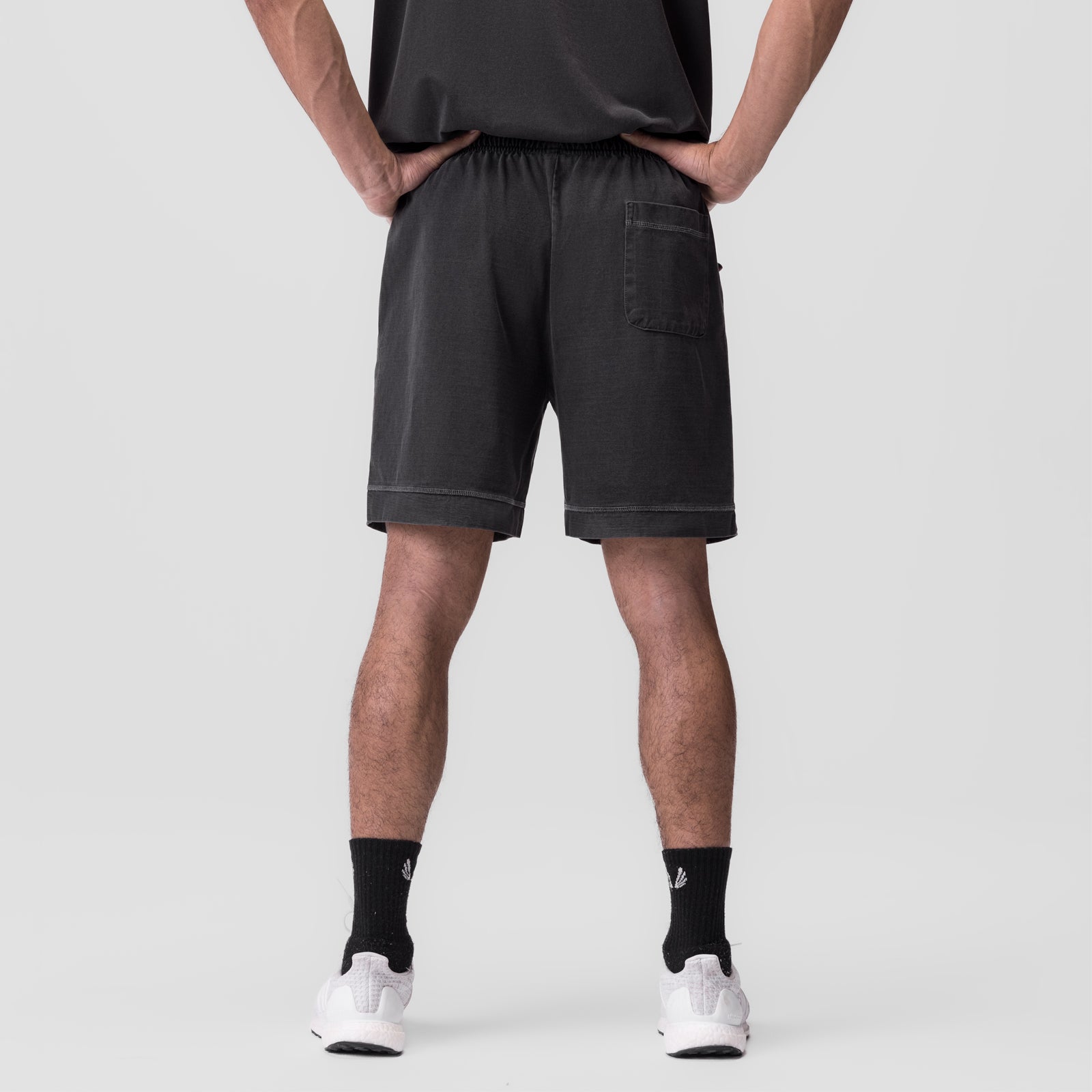Tech Essential™ Sweat Short in faded grey, back view on model wearing black socks and white shoes