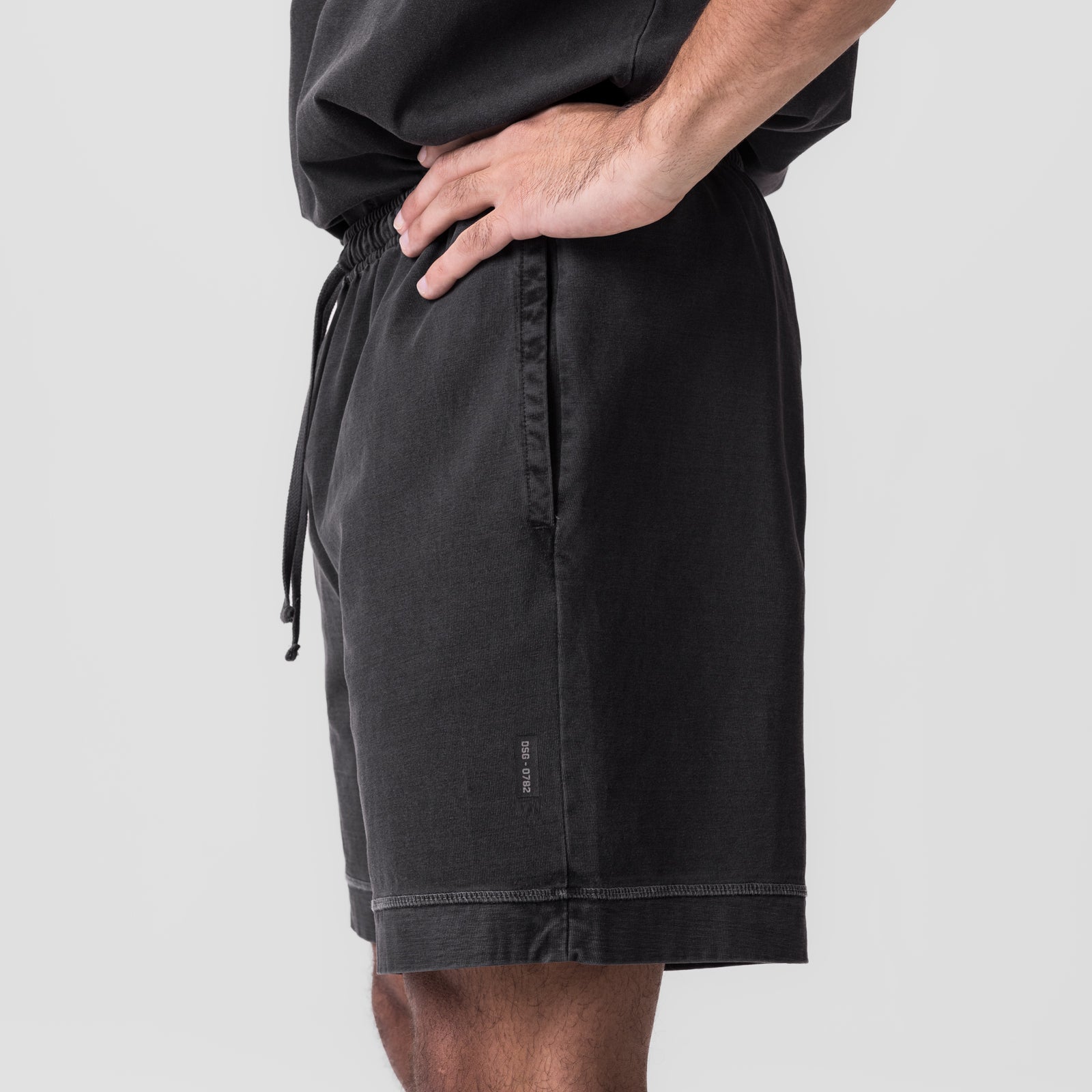 Tech Essential Sweat Short in faded grey, worn by model, side view