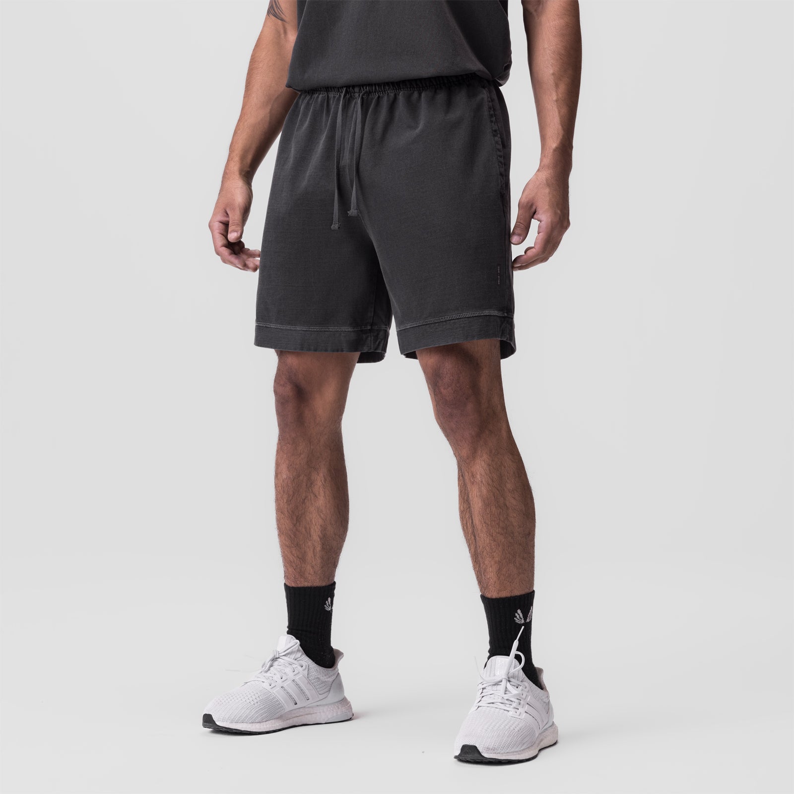 Tech Essential Sweat Short in faded grey worn by model with white sneakers and black socks