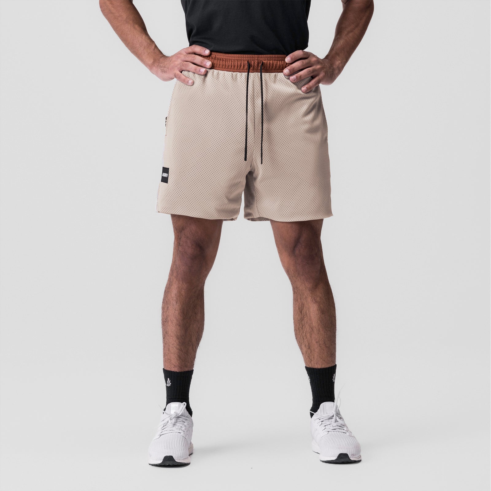 SilverPlus Mesh Reversible Short in rust/beige, modeled front view with hands on hips