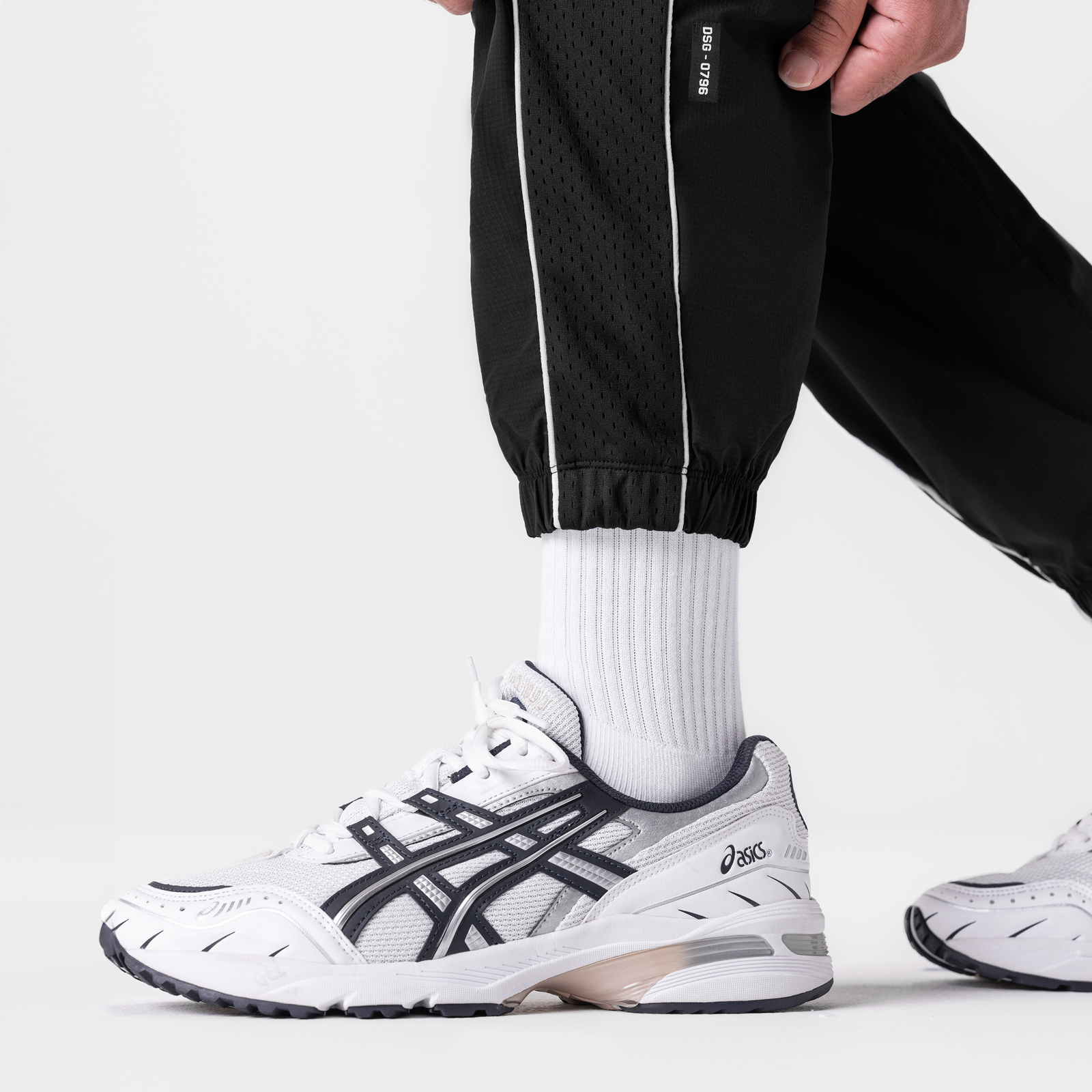 Black ripstop oversized track pant worn with white socks and sneakers, side view