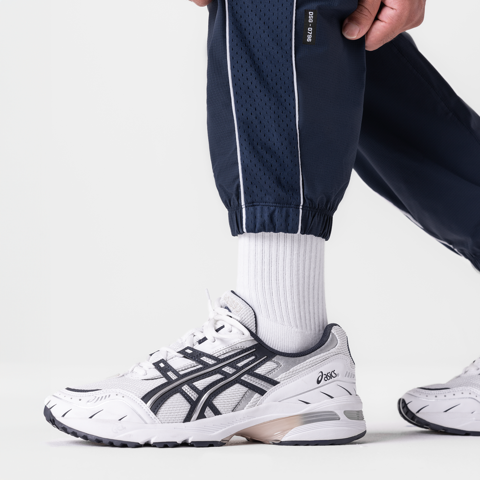 Navy ripstop oversized track pant worn with white socks and sneakers, side view