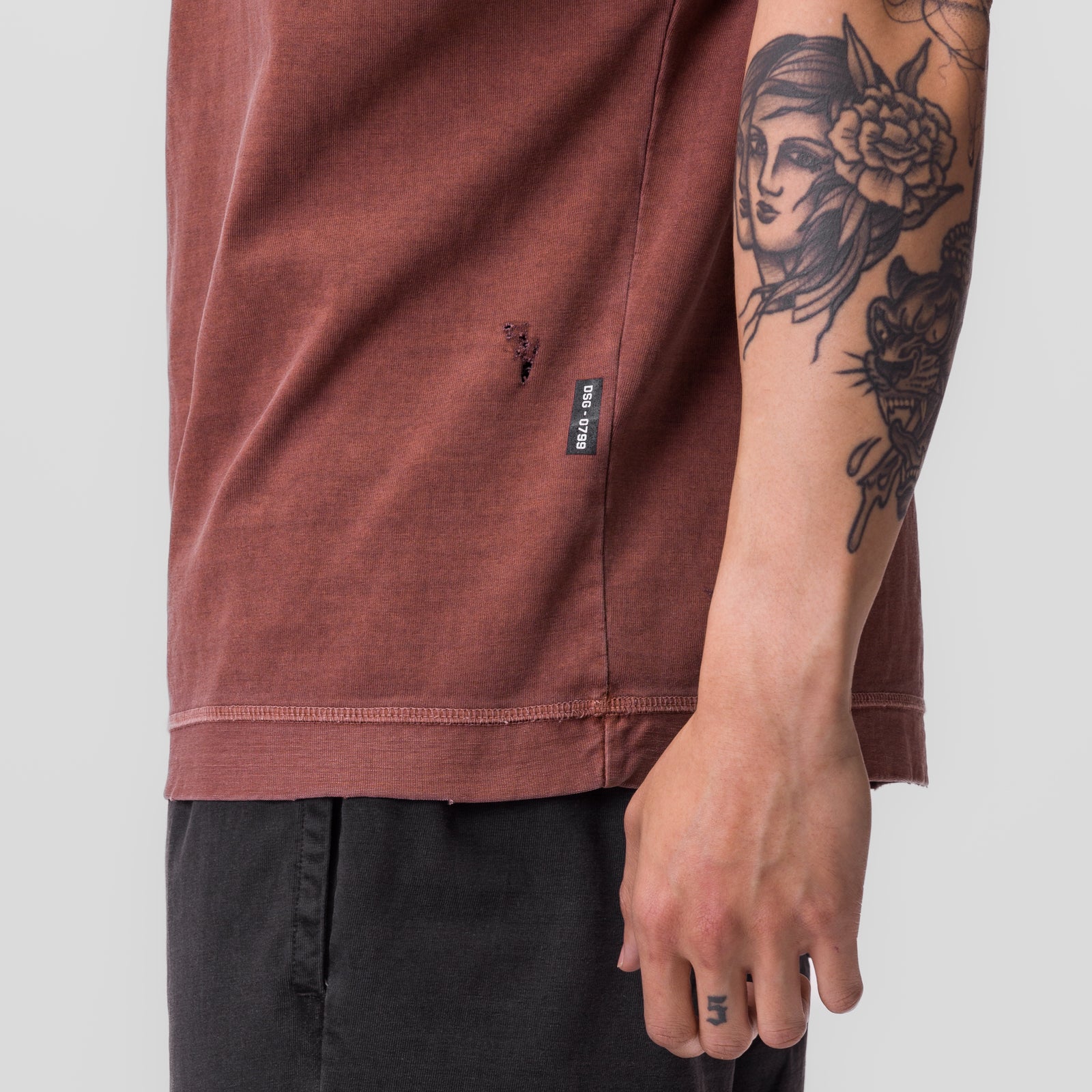 Tech Essential Cutoff Hoodie in faded brick worn by model, side view showing arm tattoos