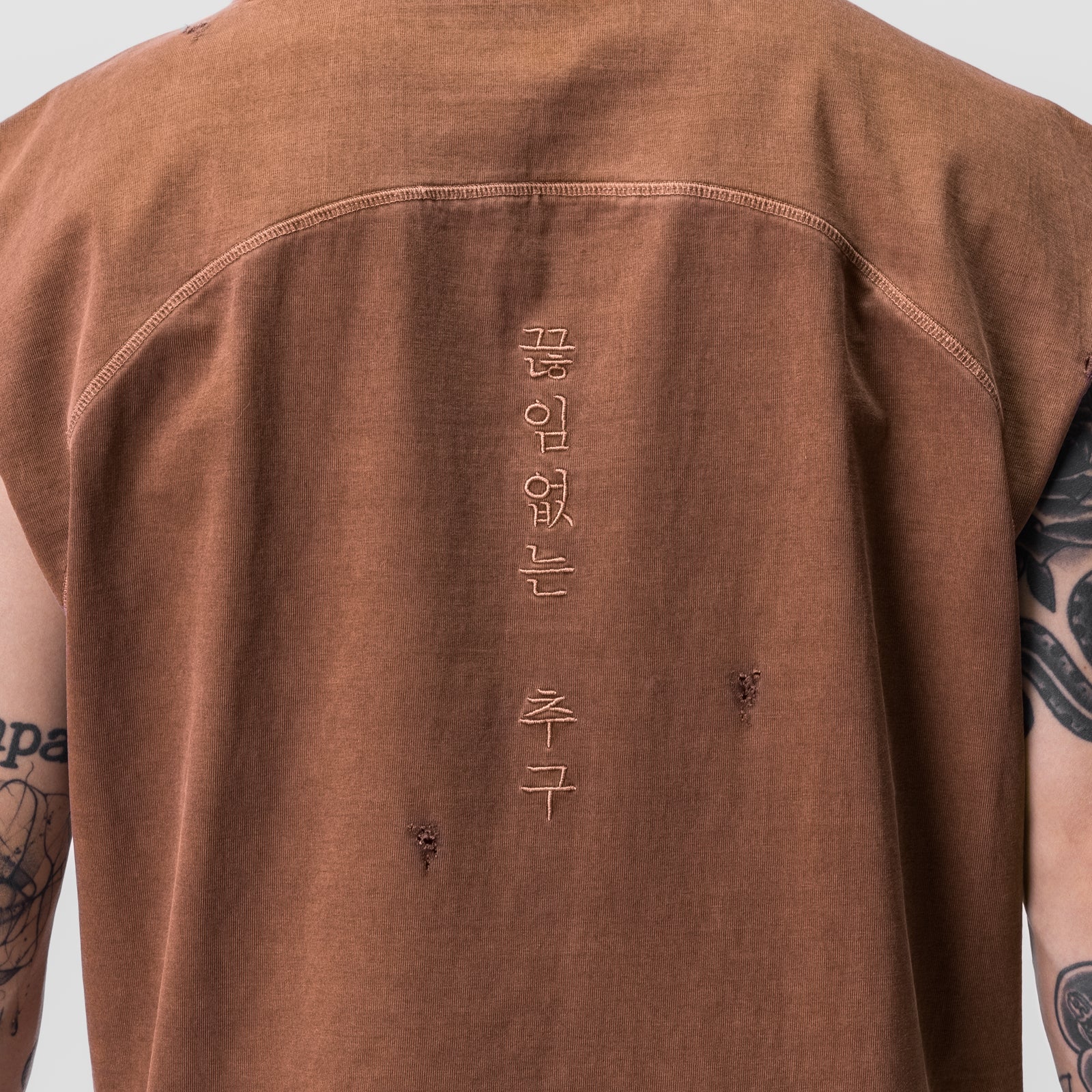 Tech Essential Cutoff Hoodie in faded rust, back view on model with visible tattoos