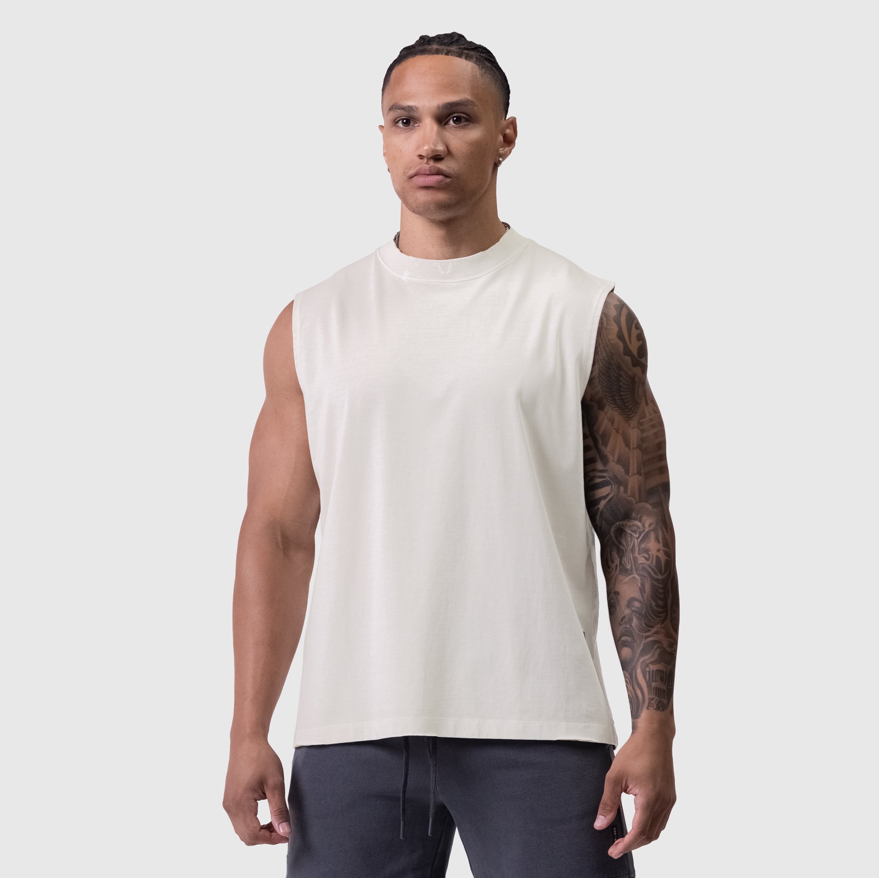Tech Essential Relaxed Cutoff sleeveless tee in faded stone, worn by model, front view
