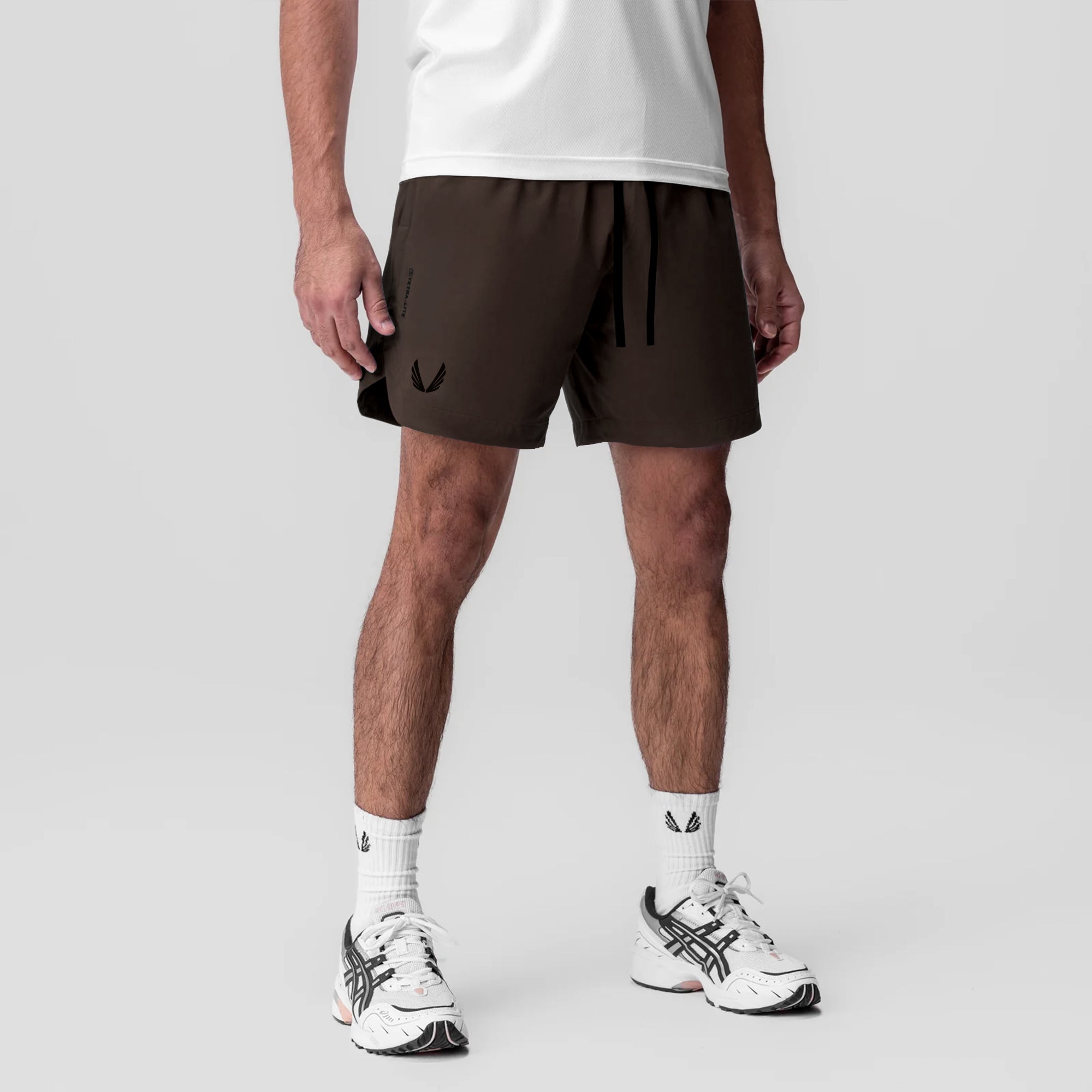 Tetra-Lite 7" Linerless Short in Dark Earth with Wings logo, worn with white socks and sneakers