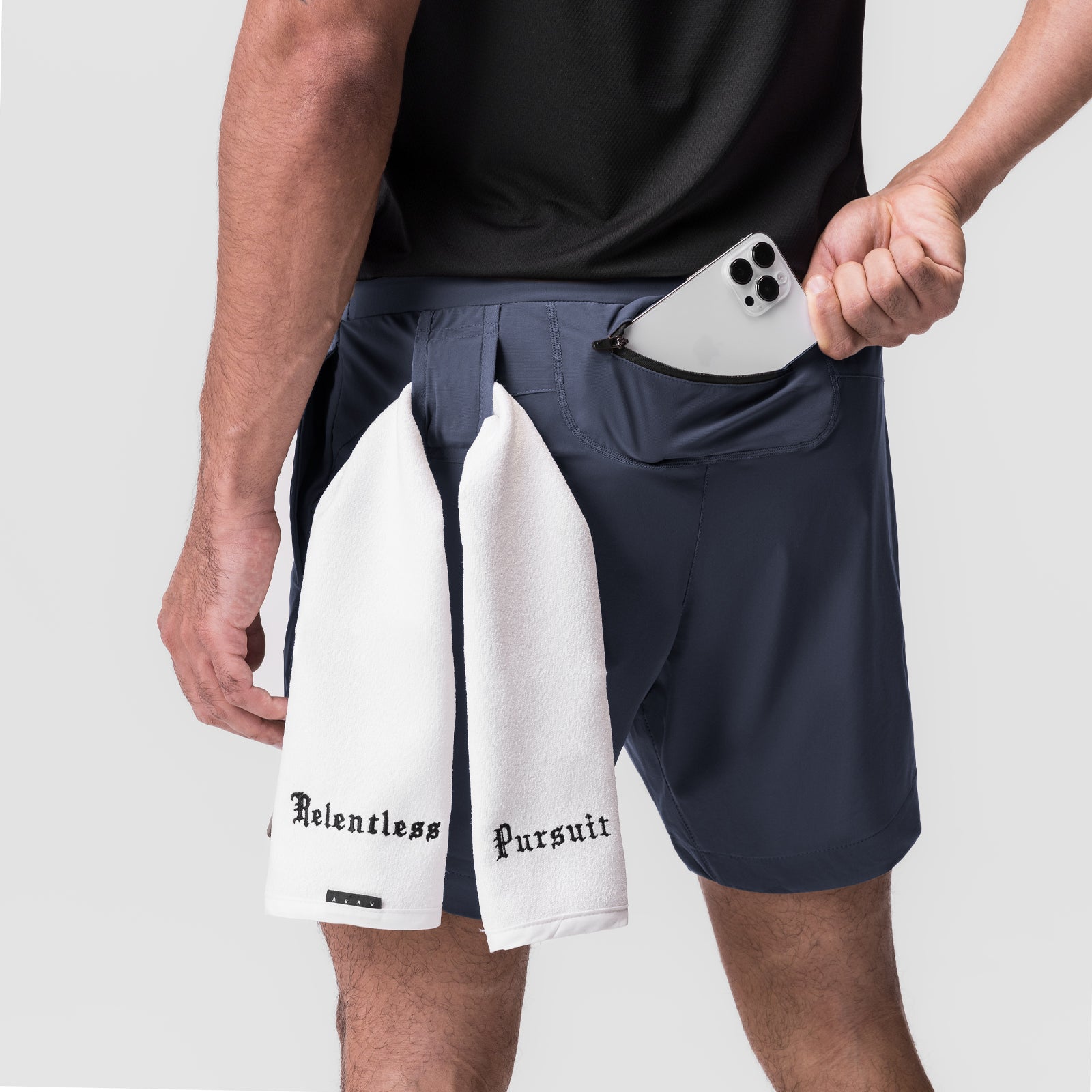 Tetra-Lite 7" Linerless Short in navy worn by model holding white towel and phone