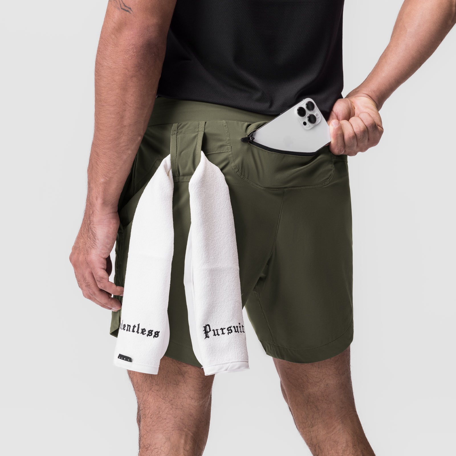Tetra-Lite 7" Linerless Short in olive worn with white towel, model holding phone