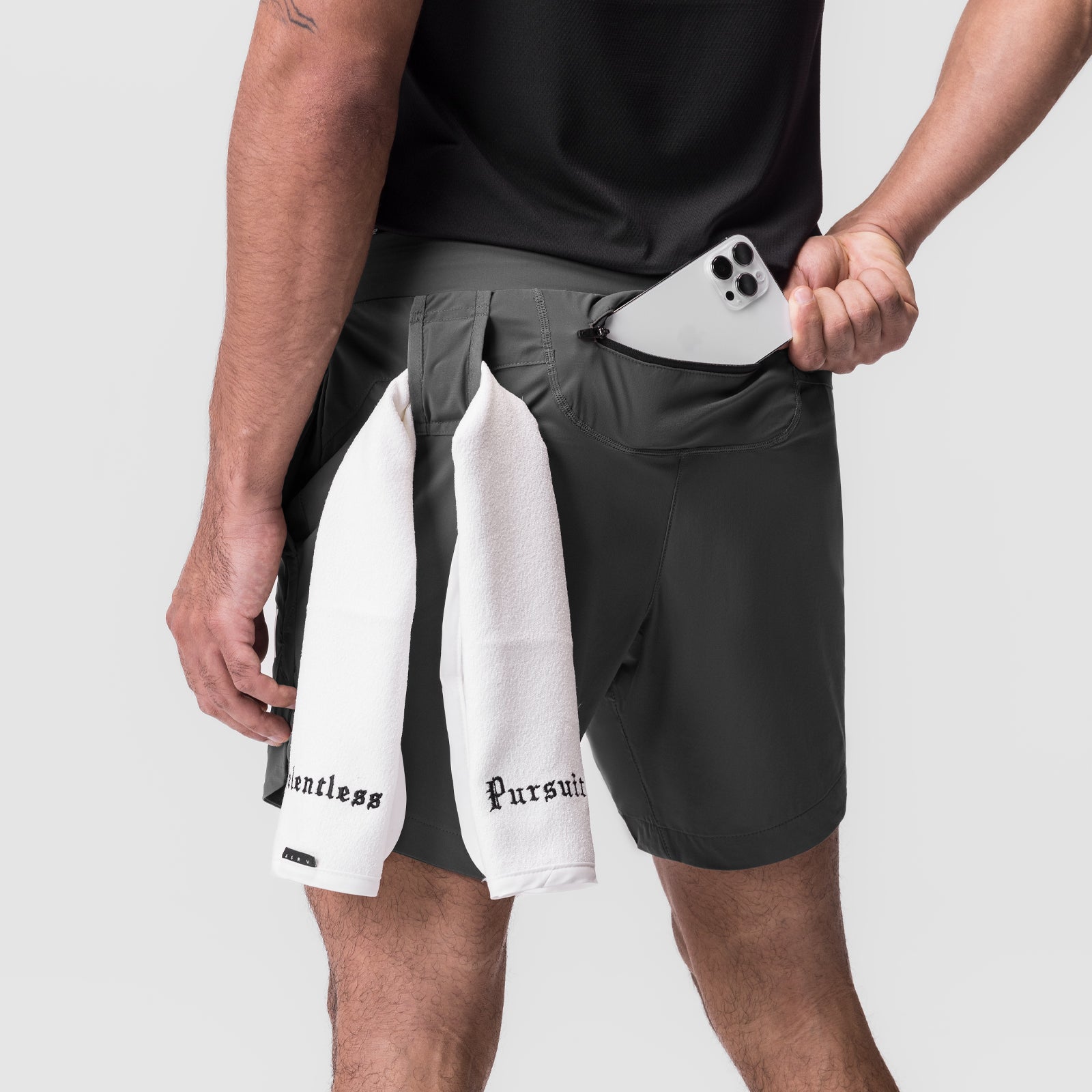 Tetra-Lite 7" Linerless Short in black worn by model holding phone, with white towel