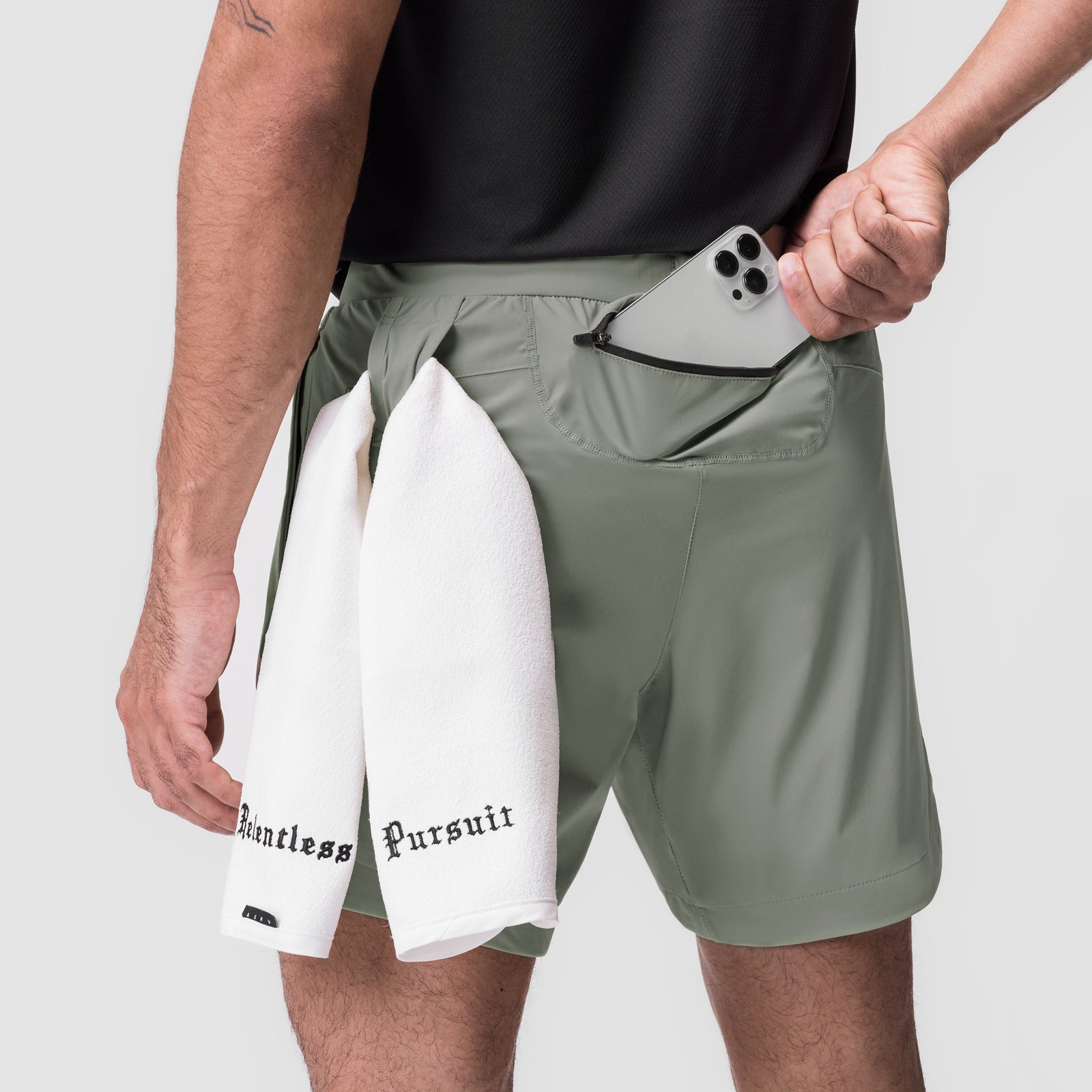 Tetra-Lite 7" Linerless Short in sage with white shorts, model holding phone in pocket