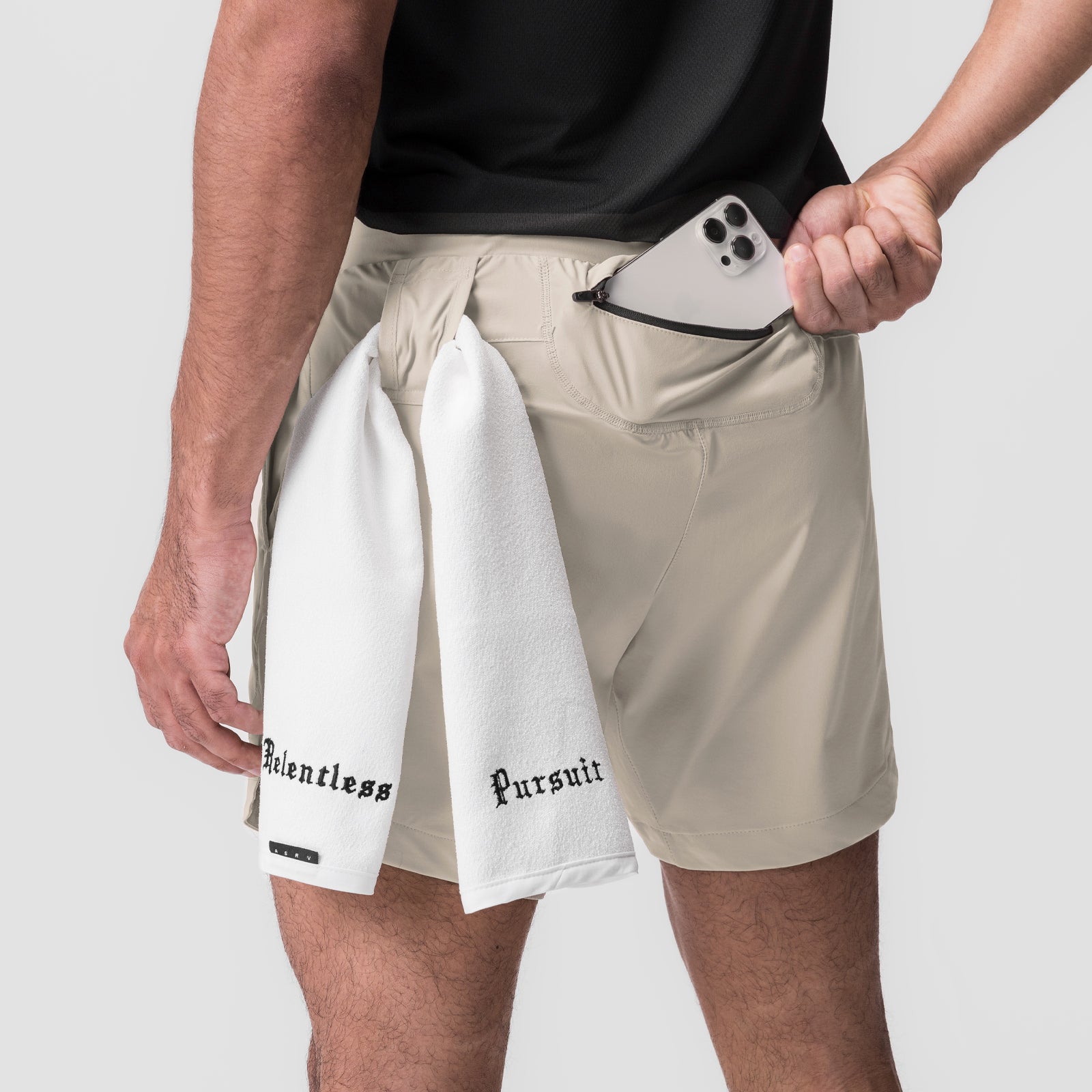 Tetra-Lite 7" Linerless Short in Sand Smoke, worn with white towel and phone in pocket