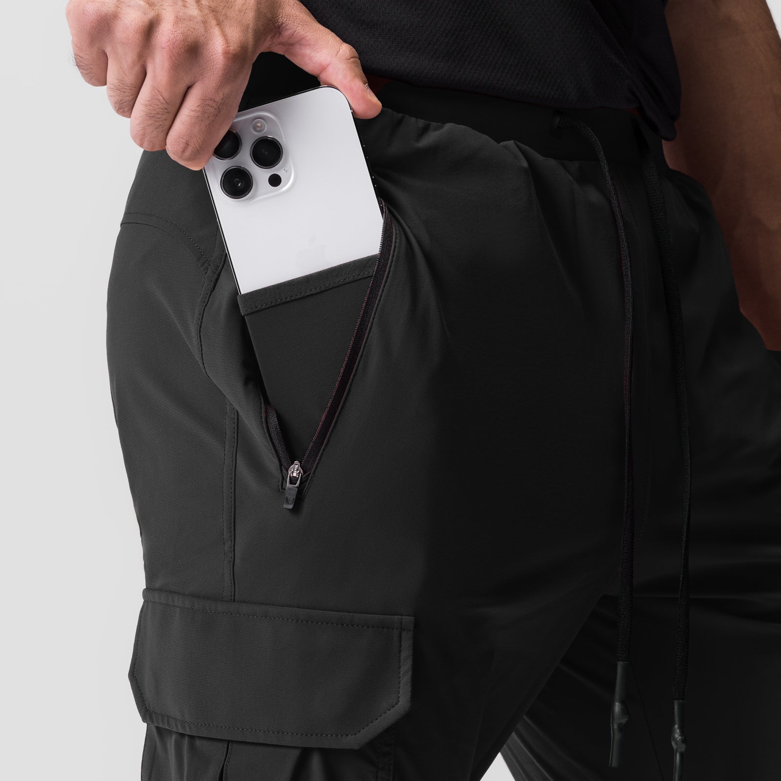 Black Tetra-Lite Cargo jogger worn by model, phone in pocket detail