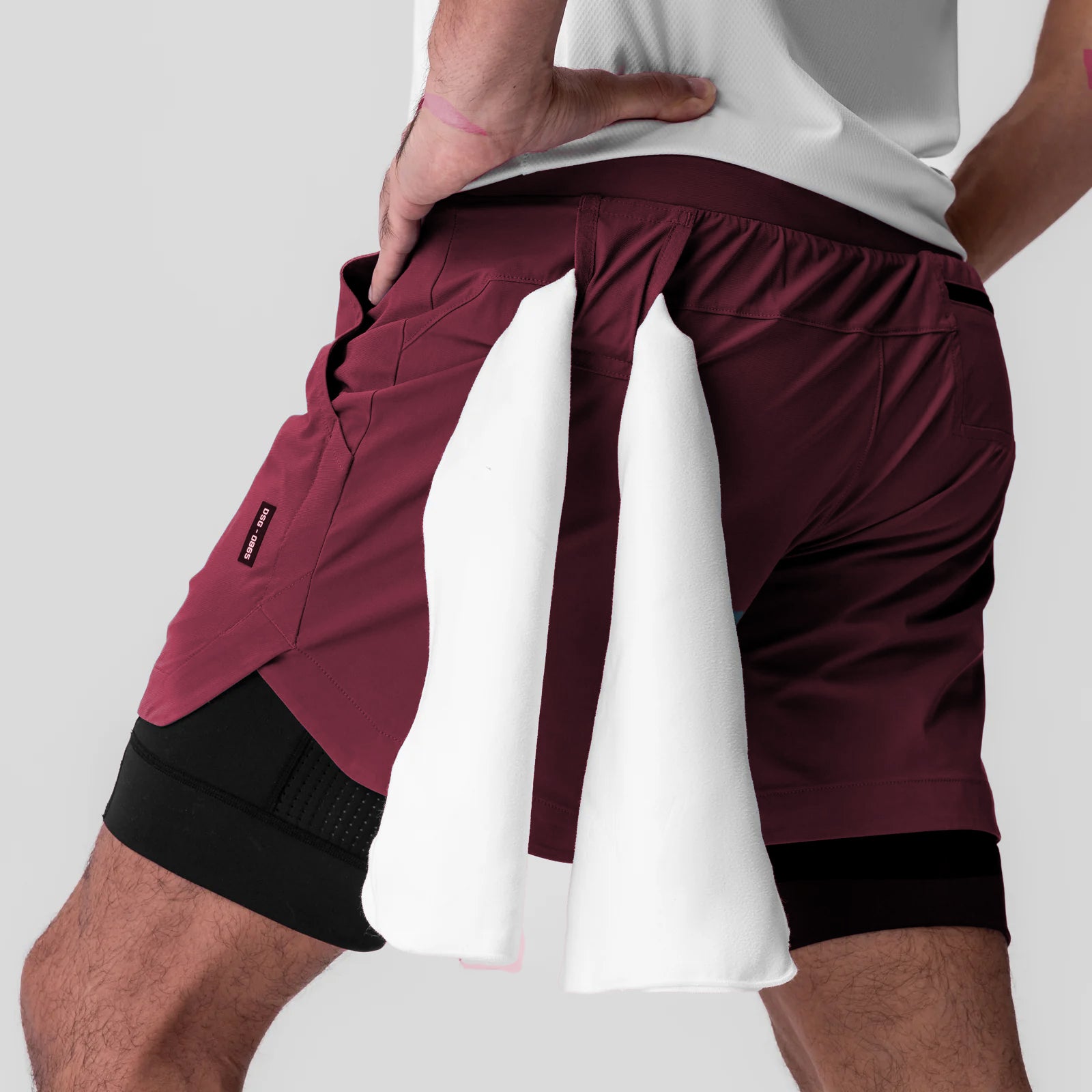 Tetra-Lite 5" Liner Short in Crimson and Black, modeled from side view with towel