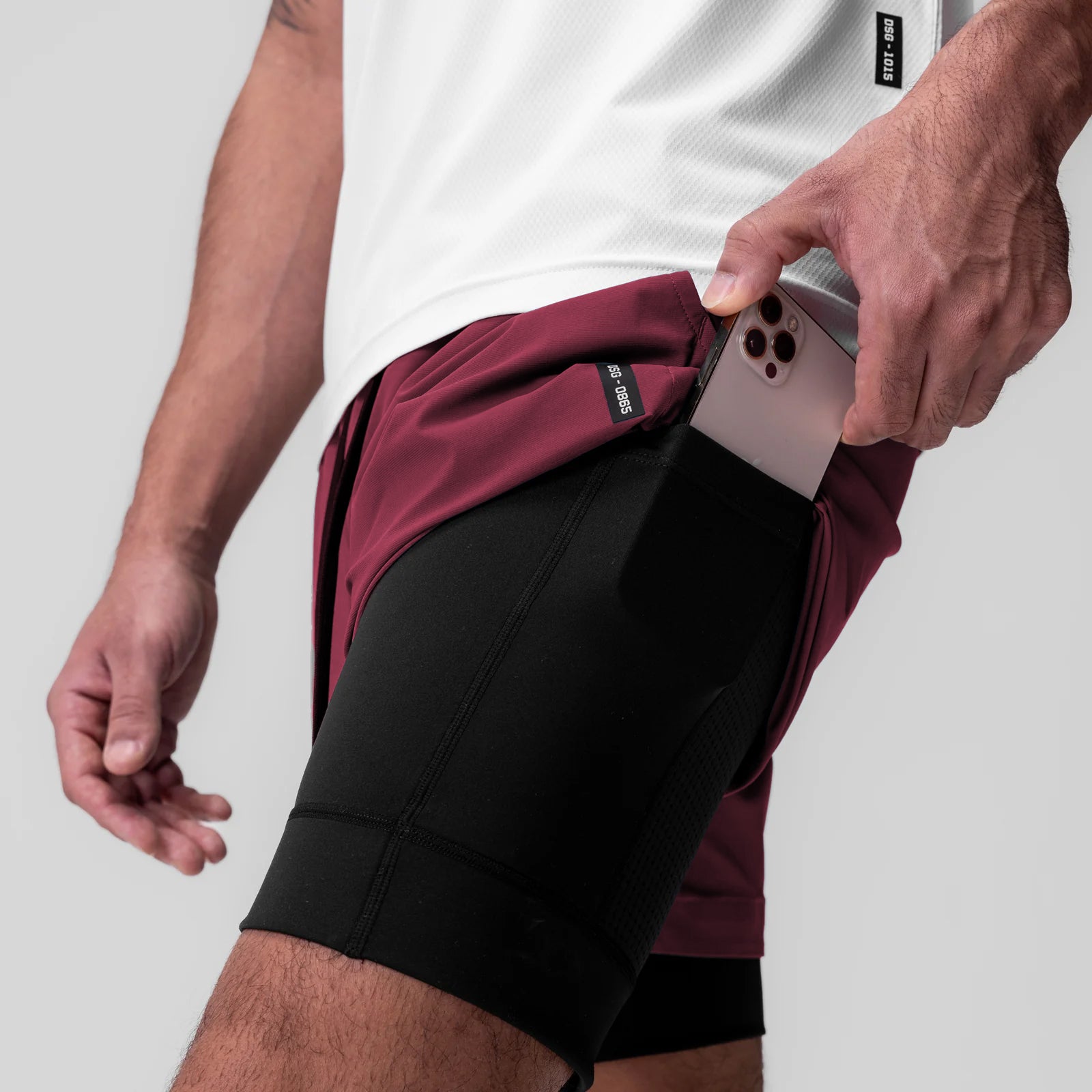 Tetra-Lite 5" Liner Short in Crimson and Black, model holding phone in front pocket