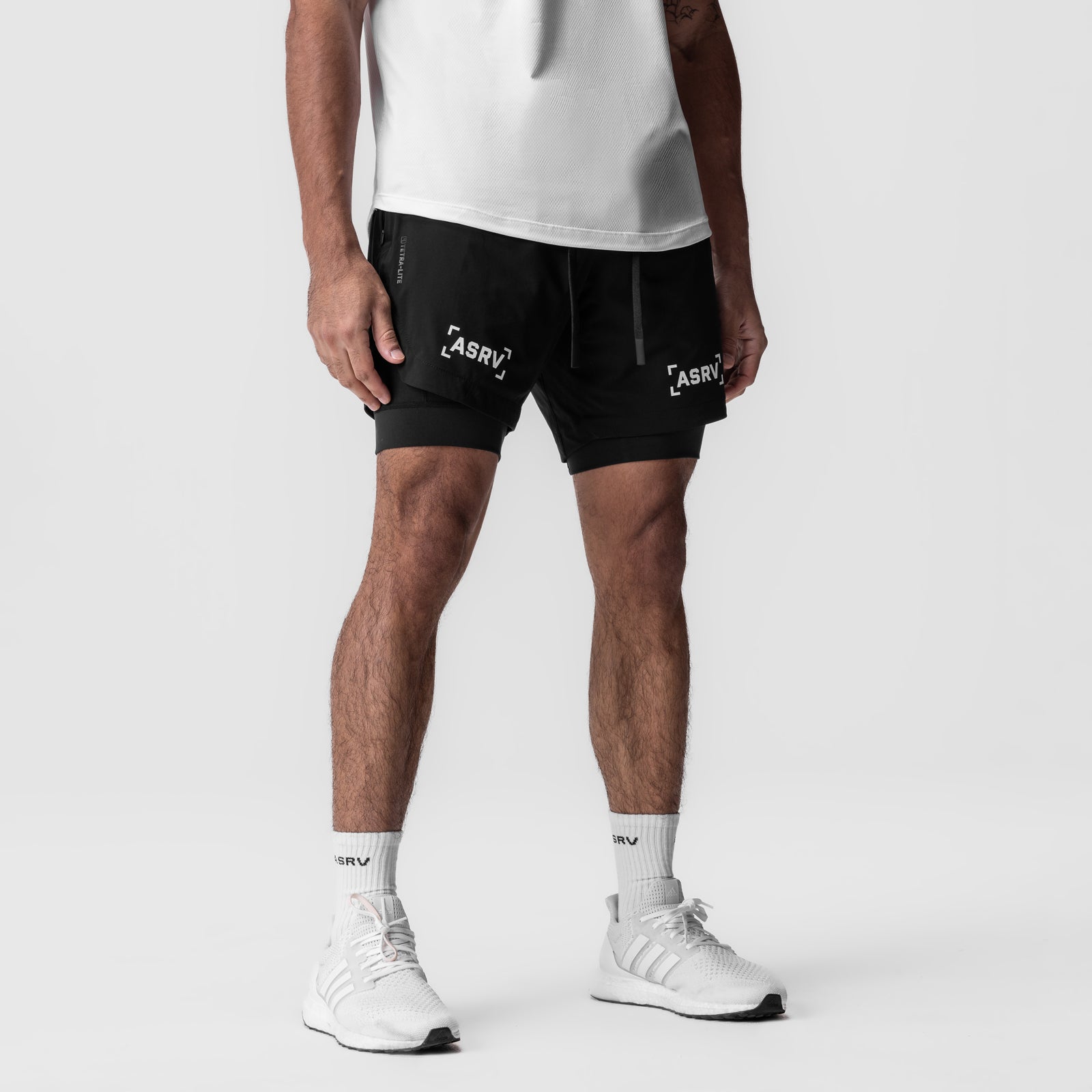 ASRV Tetra-Lite 7" Liner Short in black with white branding, worn with white socks and sneakers