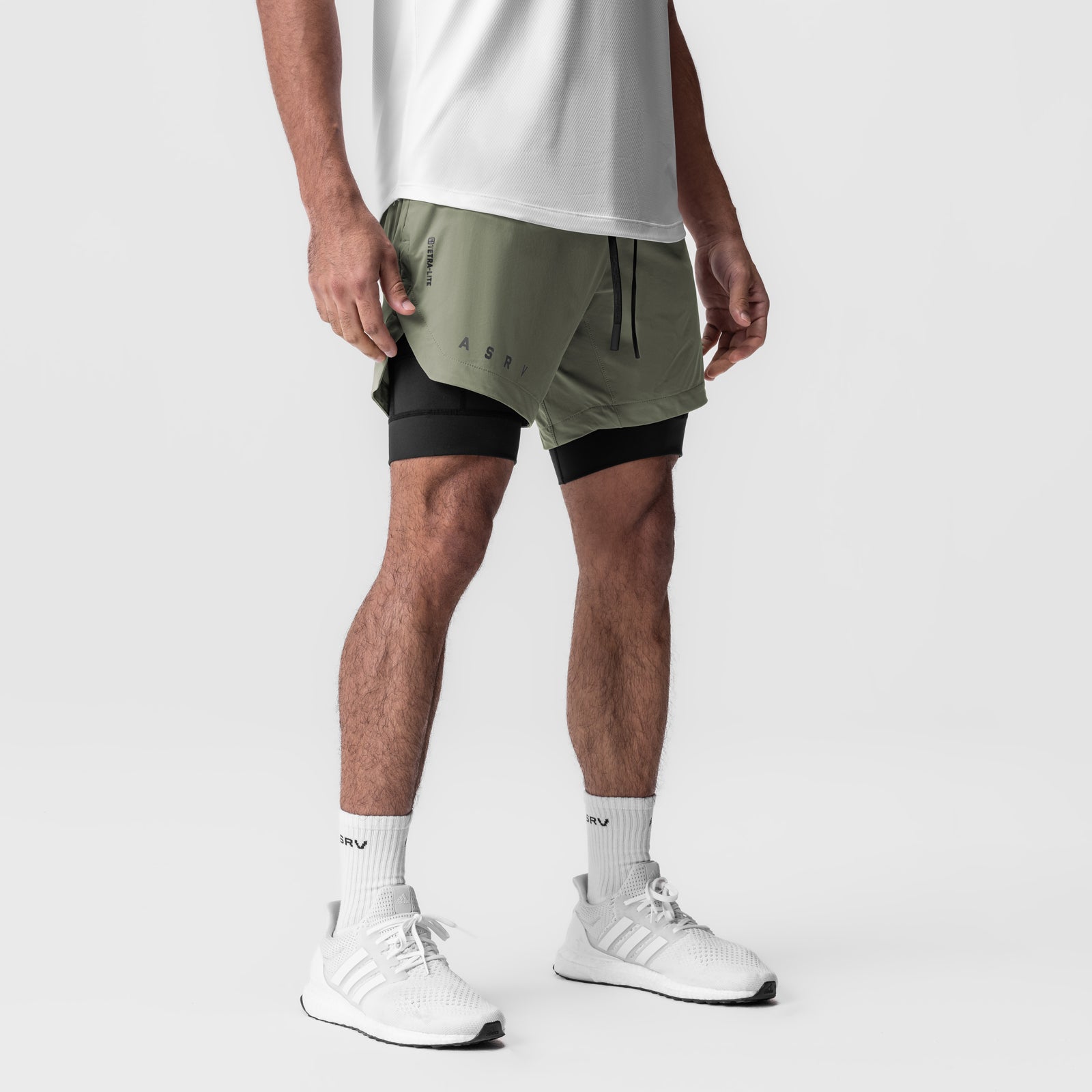 Tetra-Lite 7" Liner Short in sage and black, worn by model with white sneakers