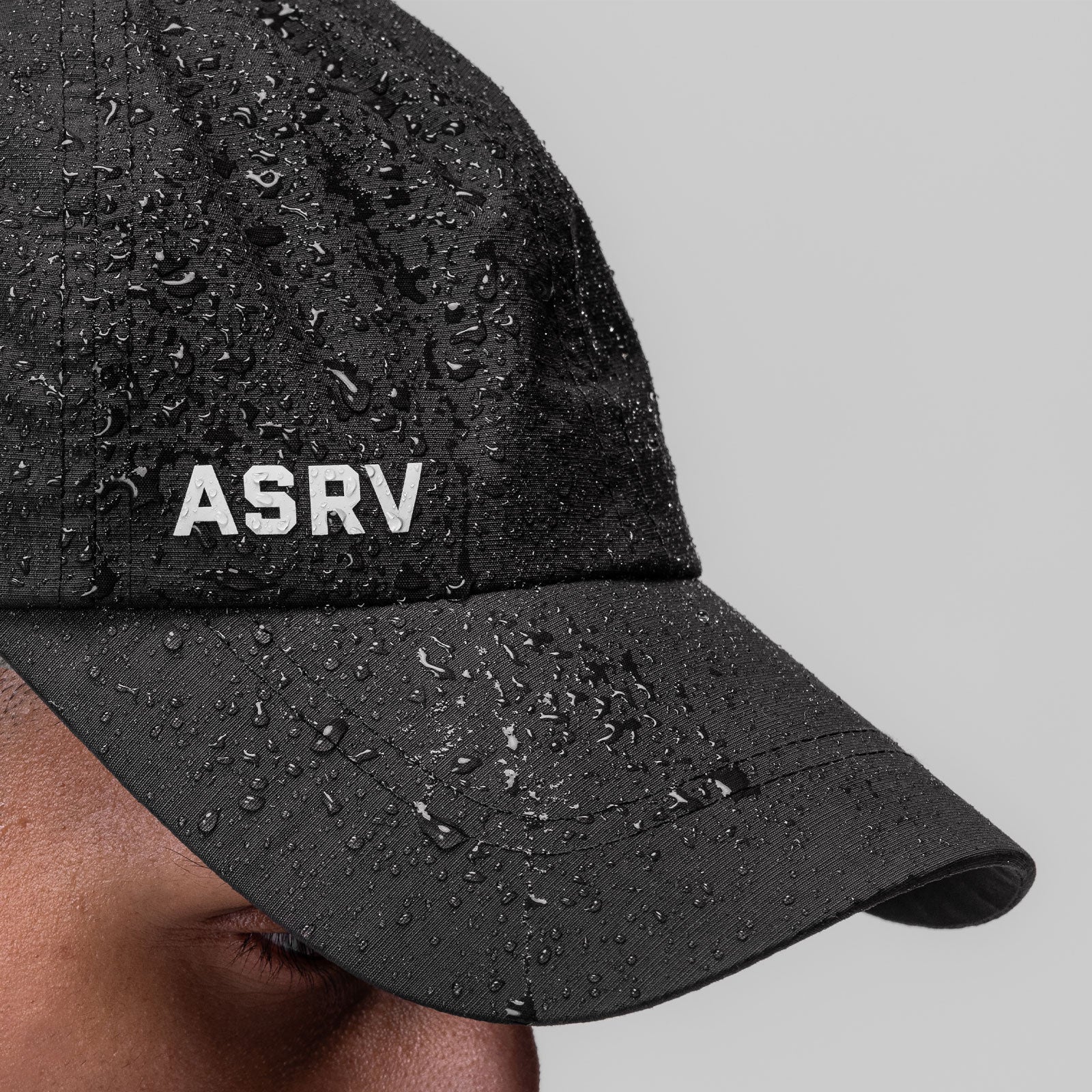 Weather-Ready Cinch Hat in black with water beads, worn by model, side view
