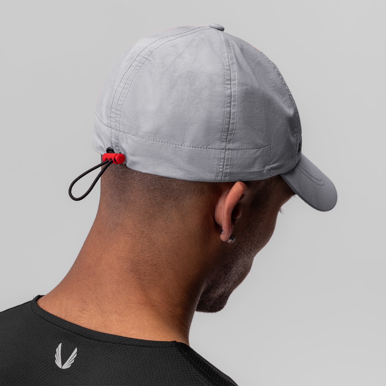 Weather-Ready Cinch Hat in grey worn by model from back view, showing adjustable drawstring detail