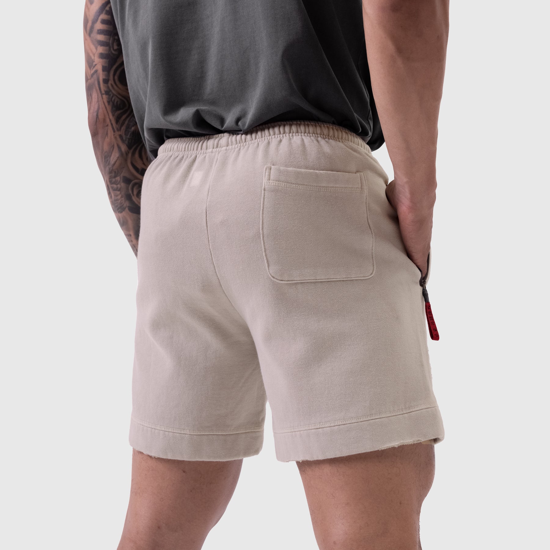 Tech Essential Sweat Short in Faded Chai, rear view on model
