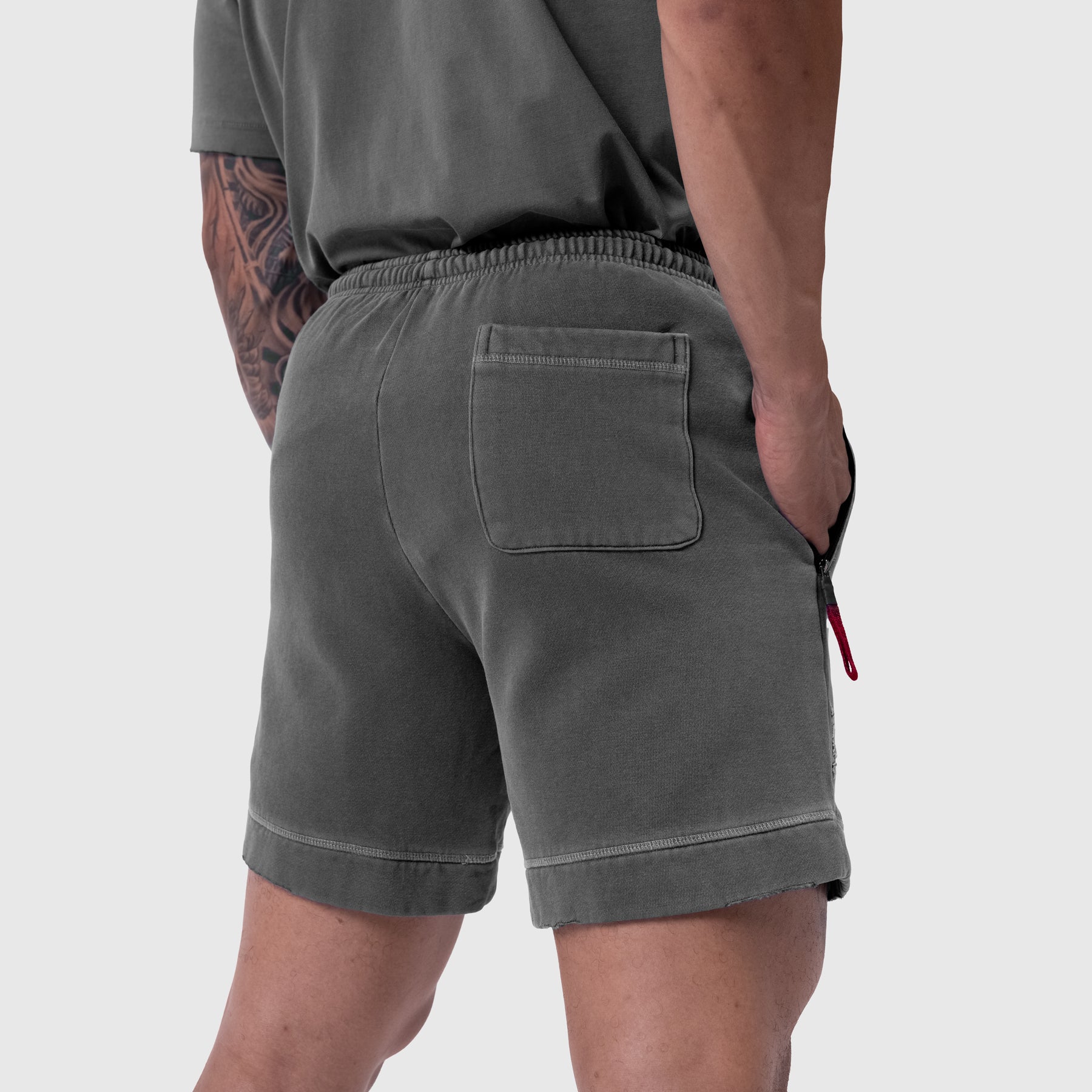 Tech Essential Sweat Short in faded grey worn by model, back view showing pocket detail