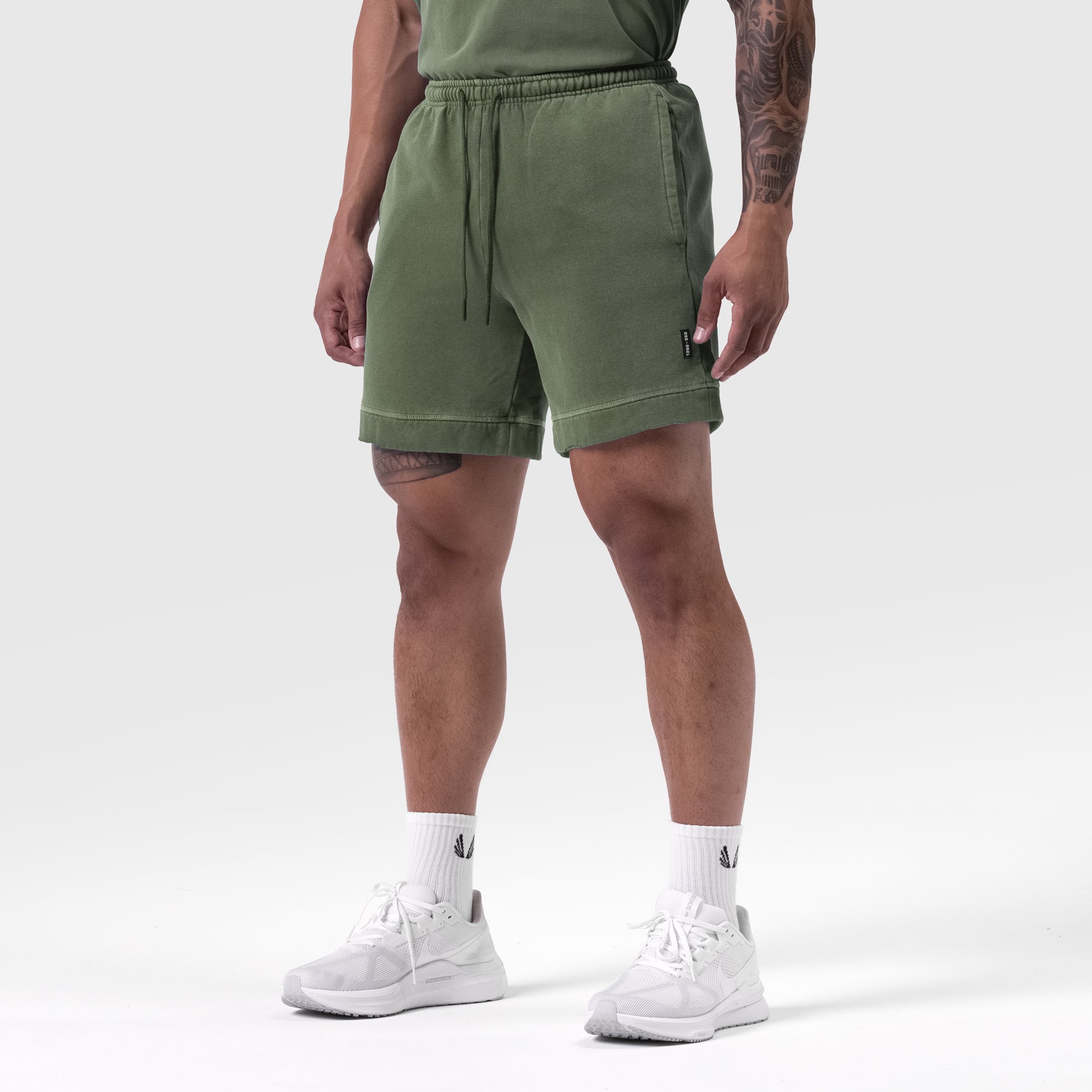 Tech Essential Sweat Short in Faded Olive worn by model with white sneakers, front view