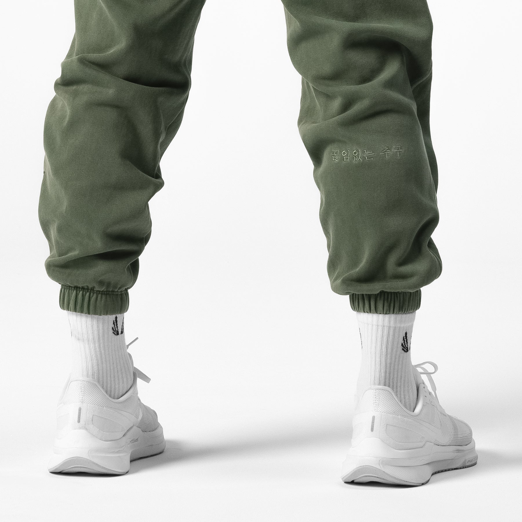 Tech Essential™ Sweats in faded olive worn with white socks and sneakers, back view