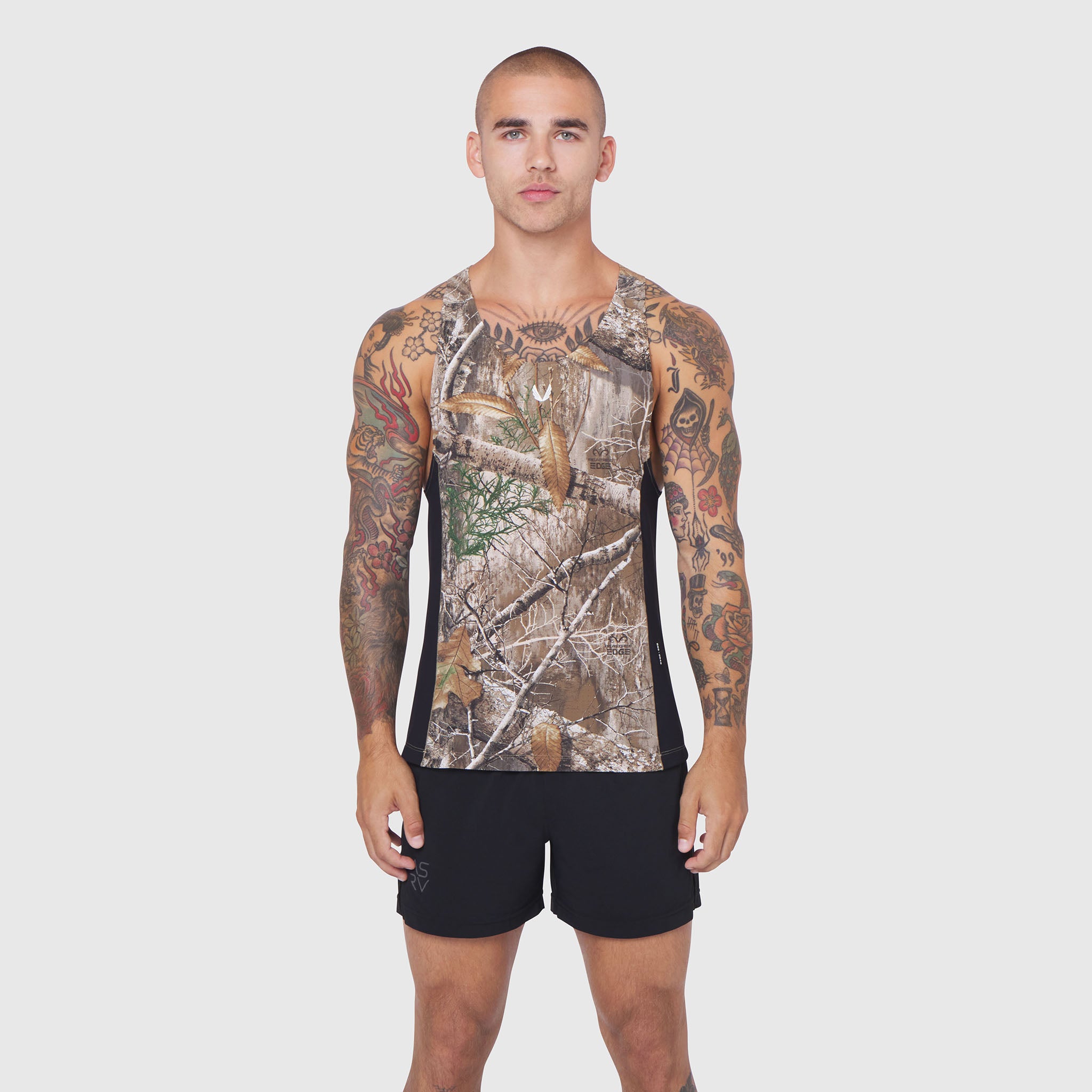 Laser-Vent Singlet Tank in Realtree Edge camo, modeled with black shorts, front view