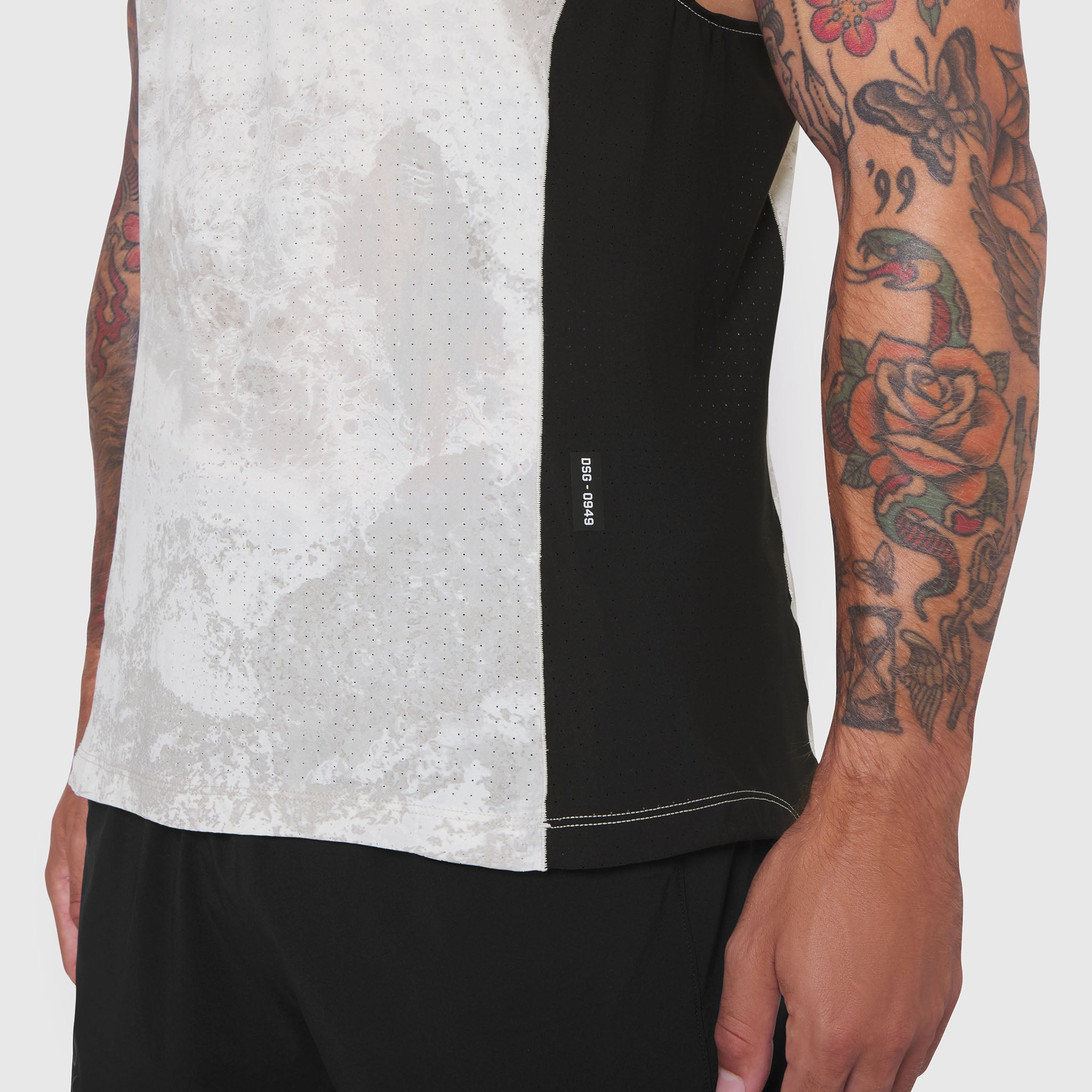 Laser-Vent Singlet Tank in white and black, worn by model showing side view with tattoos visible