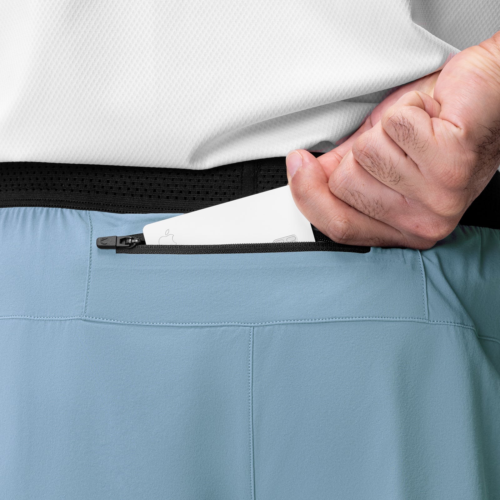 Aerotex Hybrid Liner Short in Light Sky with Black waistband, worn with hand pulling zipper pocket detail