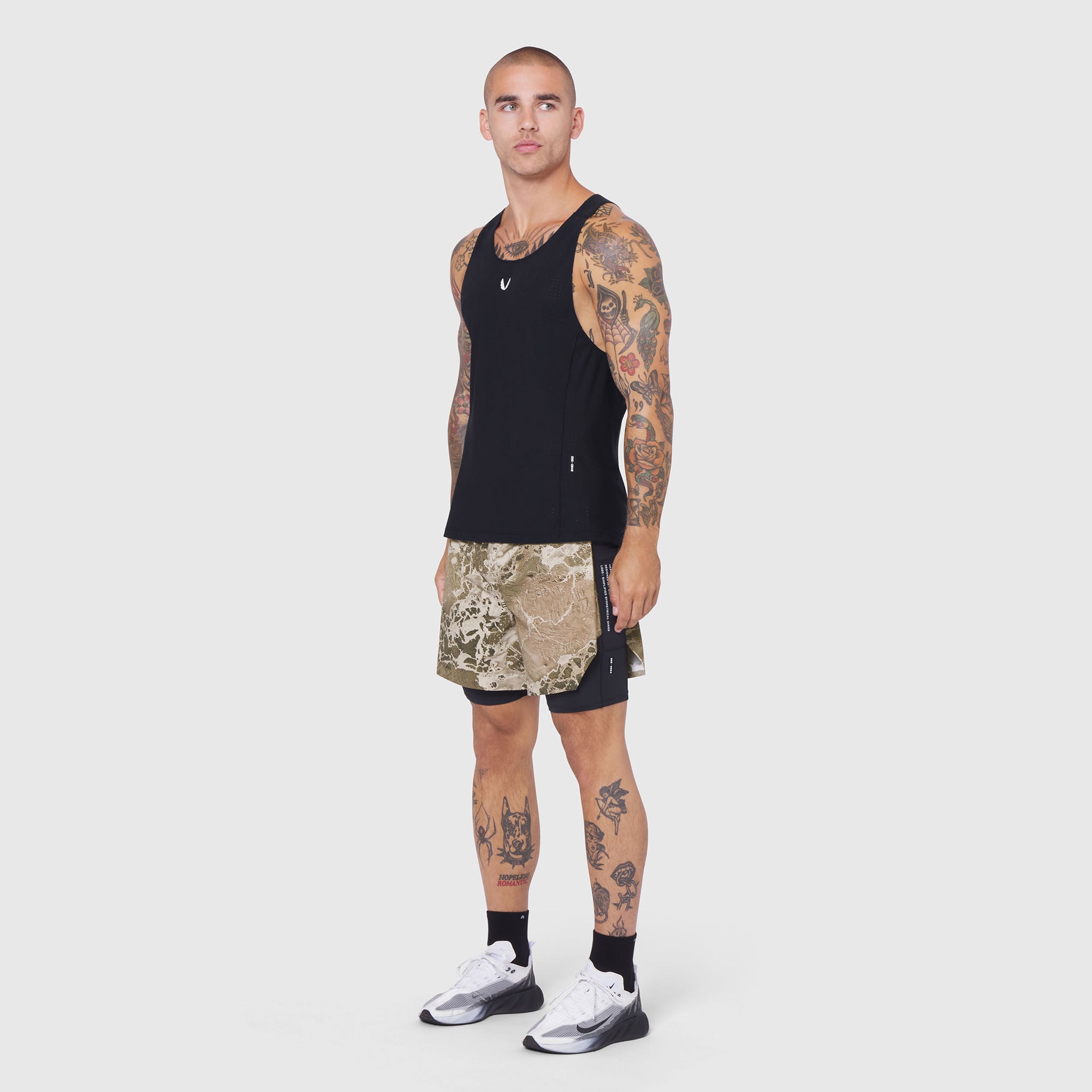 Aerotex Hybrid Liner Short in camo and black, worn by model with full-length front view