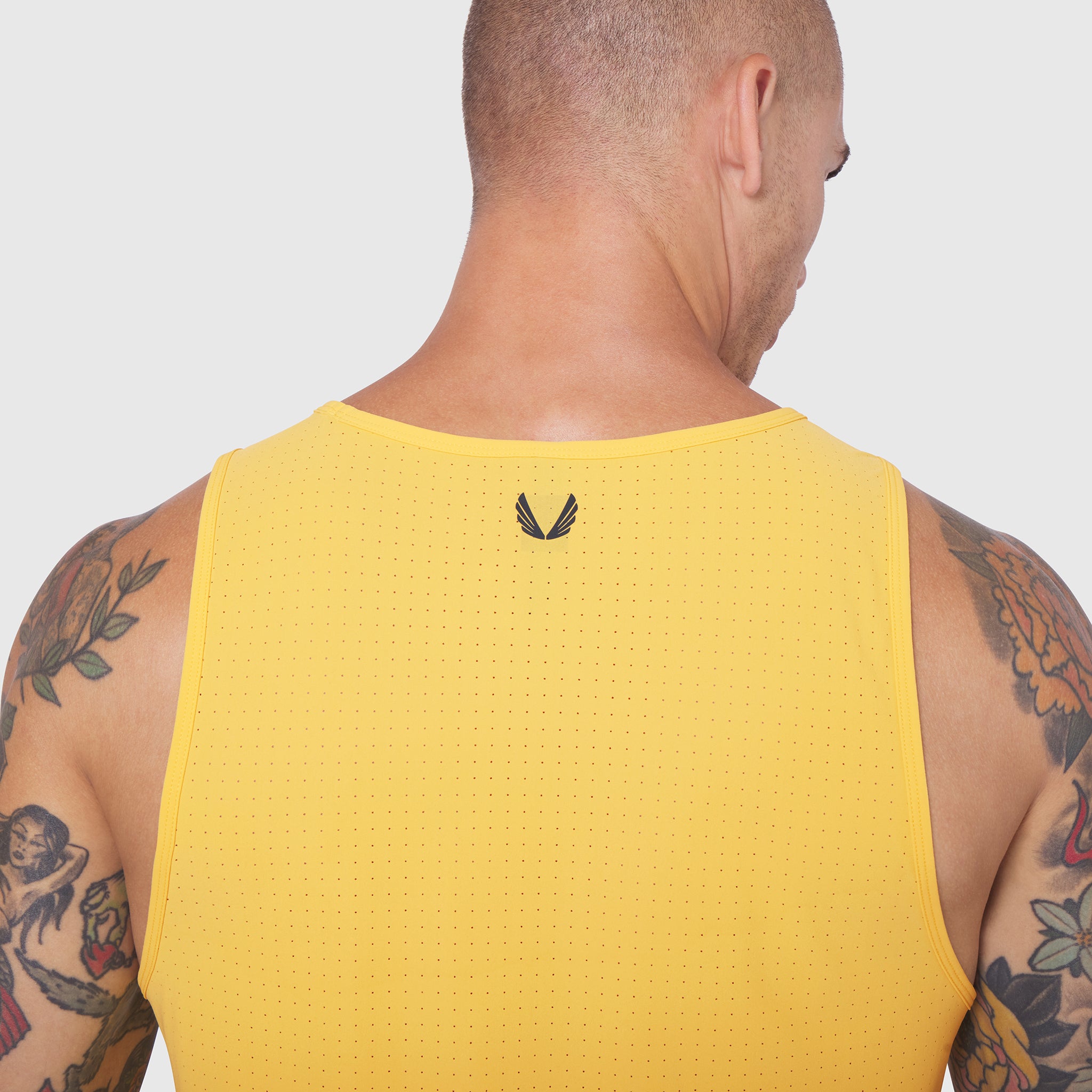 Laser-Vent Tank Top in amber yellow worn by model, back view showing perforated mesh fabric