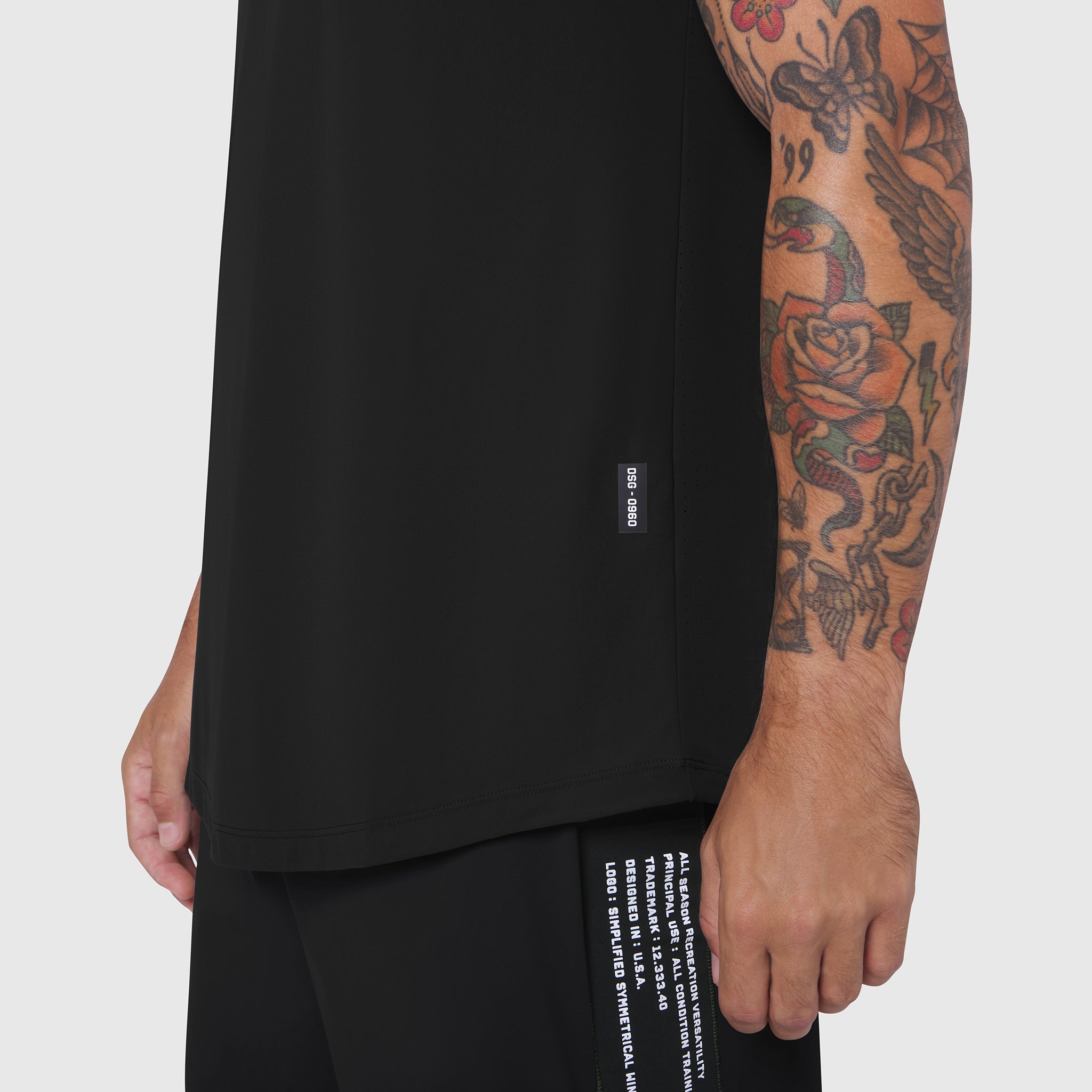 Black Laser-Vent Tank Top worn by model showing side view with tattoo visible on arm