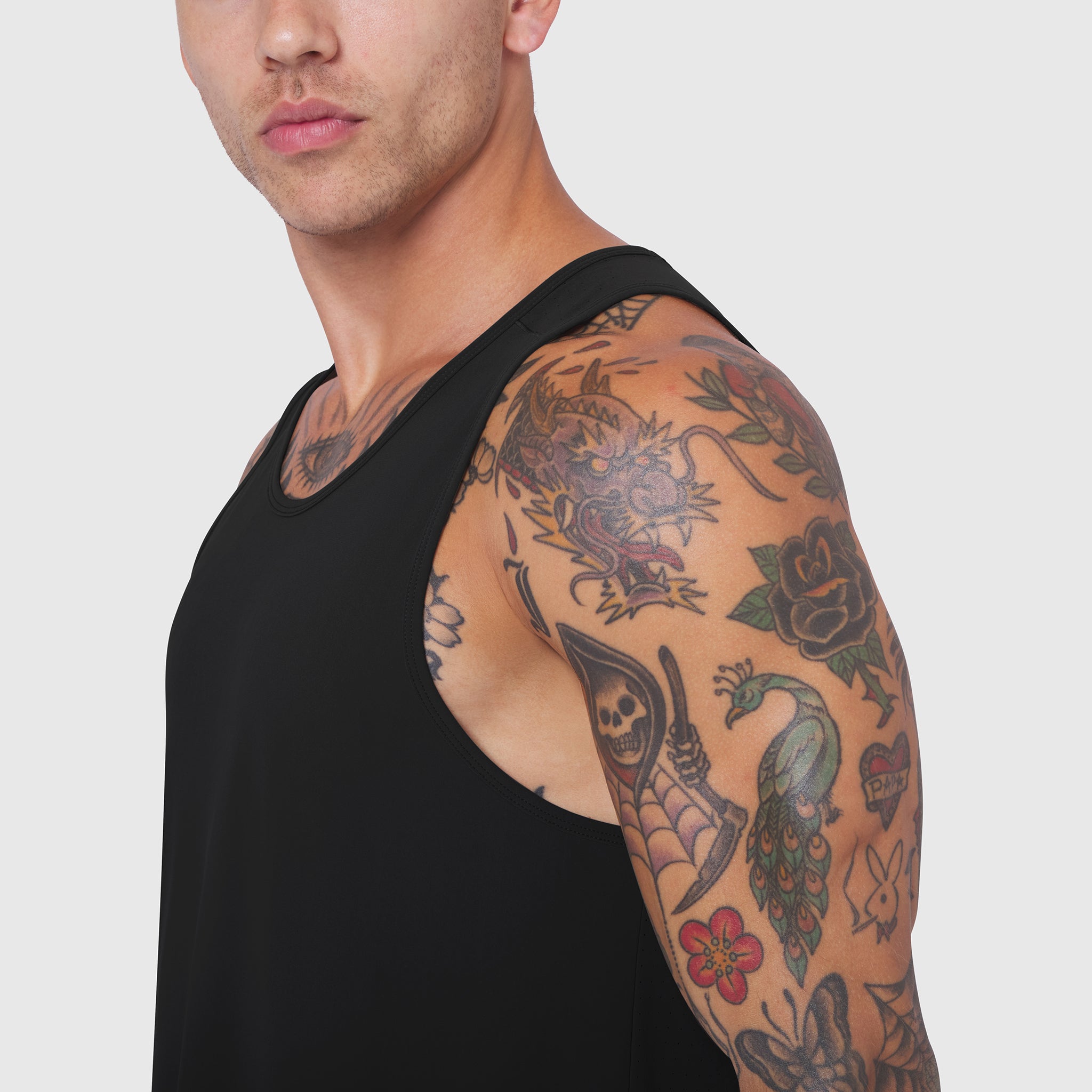 Black Laser-Vent™ Tank Top worn by model showing sleeve tattoos, side view