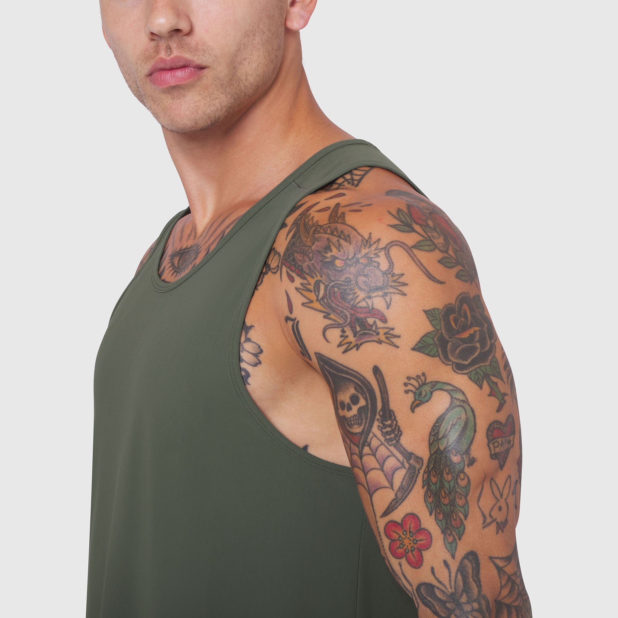 Laser-Vent Tank Top in olive worn by model, side view showcasing sleeve and tattoos