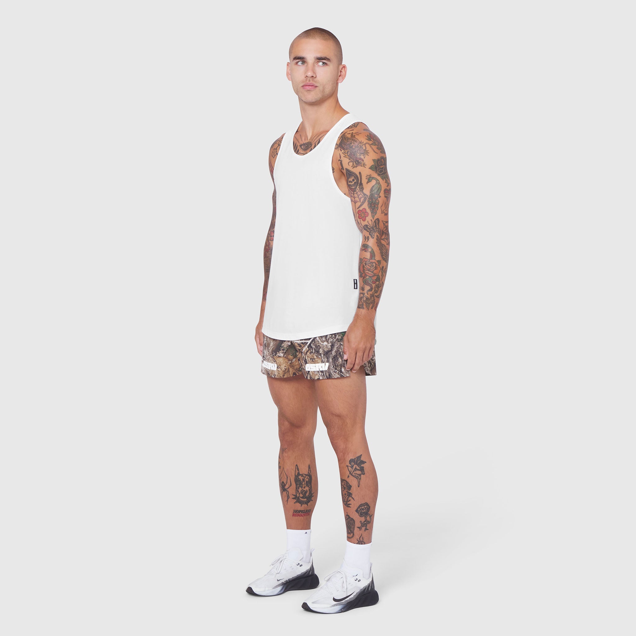 White Laser-Vent Tank Top worn with patterned shorts, front side view on model