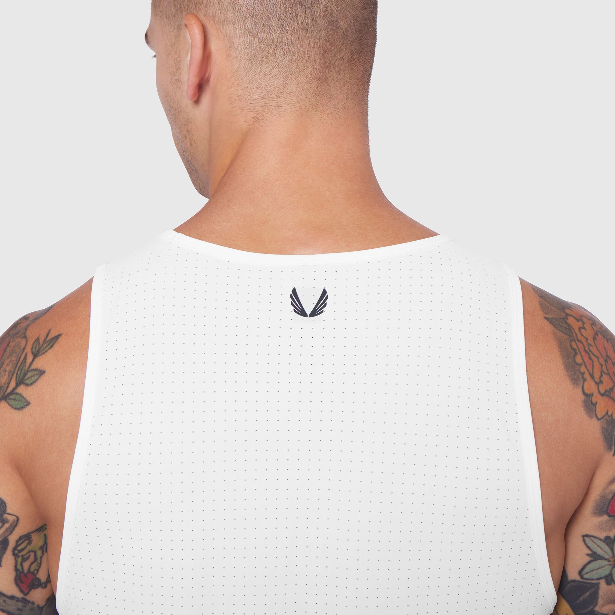 White Laser-Vent Tank Top worn by model, back view showing perforated mesh fabric and brand logo