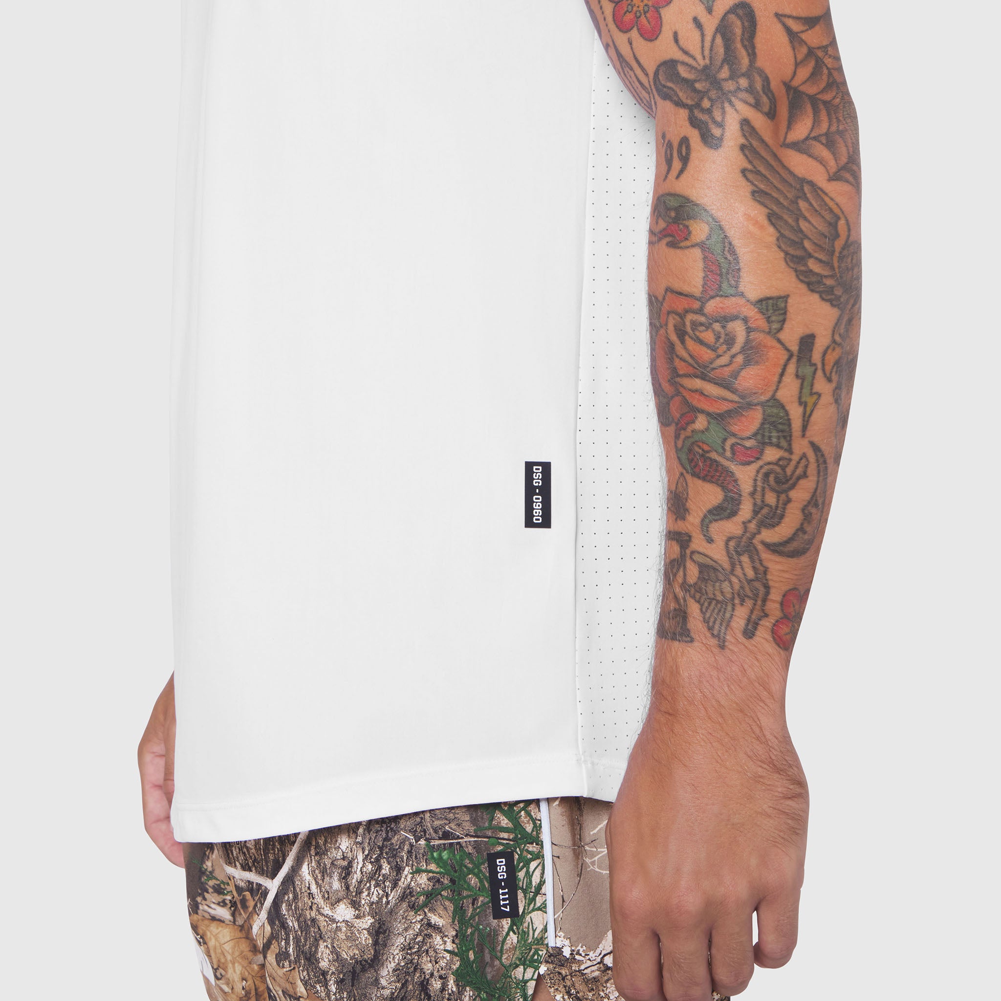 White Laser-Vent Tank Top worn by model with tattoos, side view showing mesh ventilation