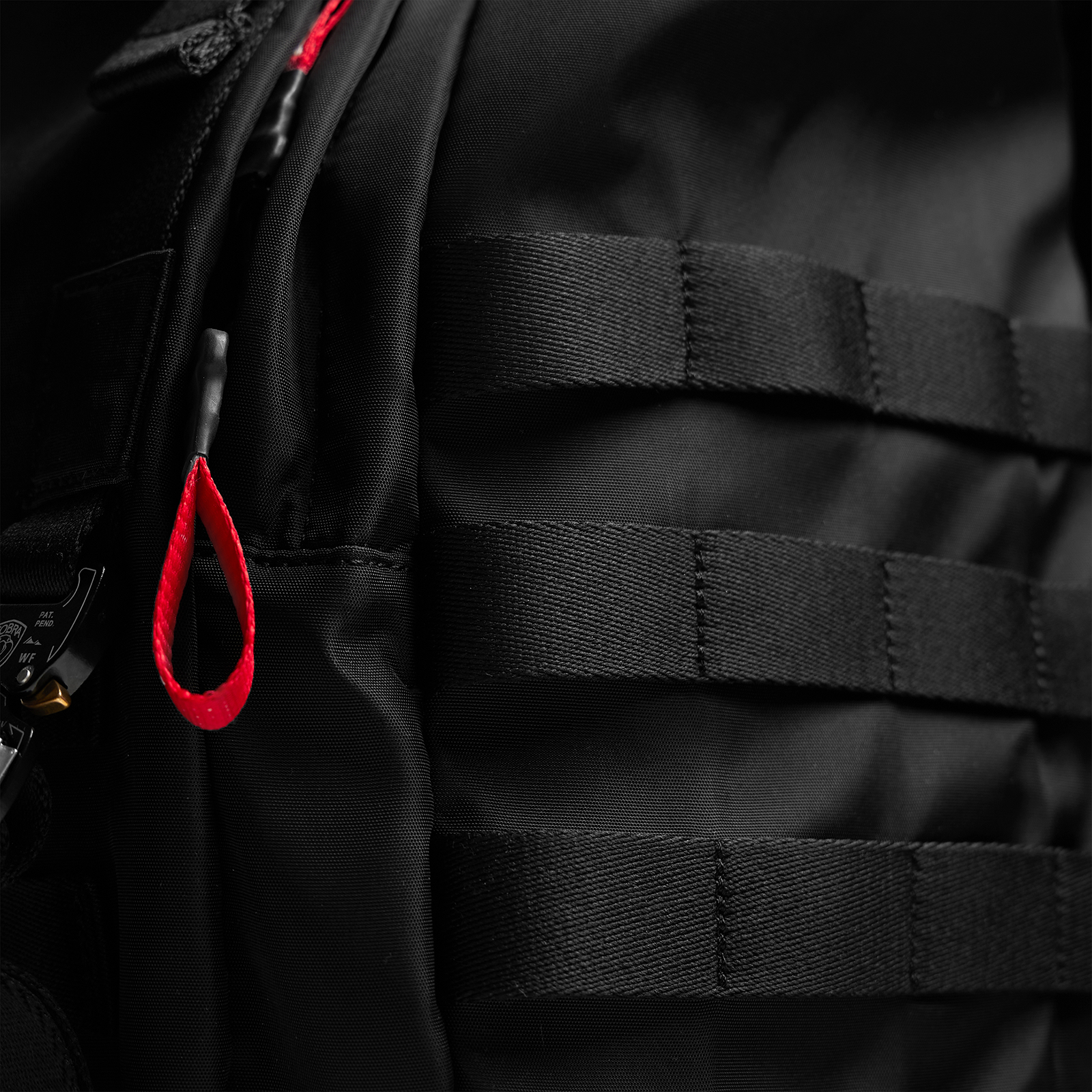 Waterproof MOLLE Backpack in black, worn detail shot showing red zipper pull