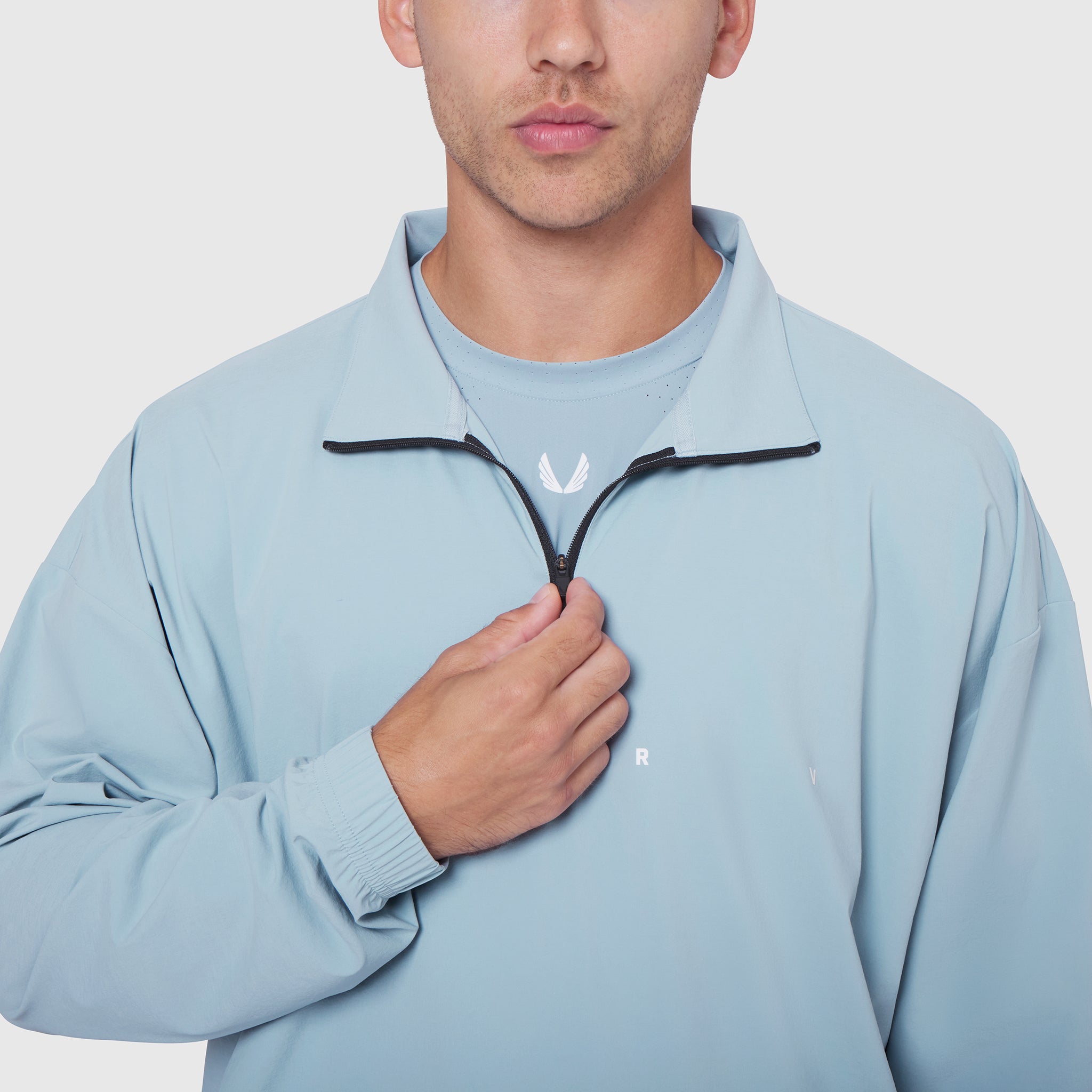 Aerotex Quarter-Zip Jacket in light sky, worn by model with hand at zipper