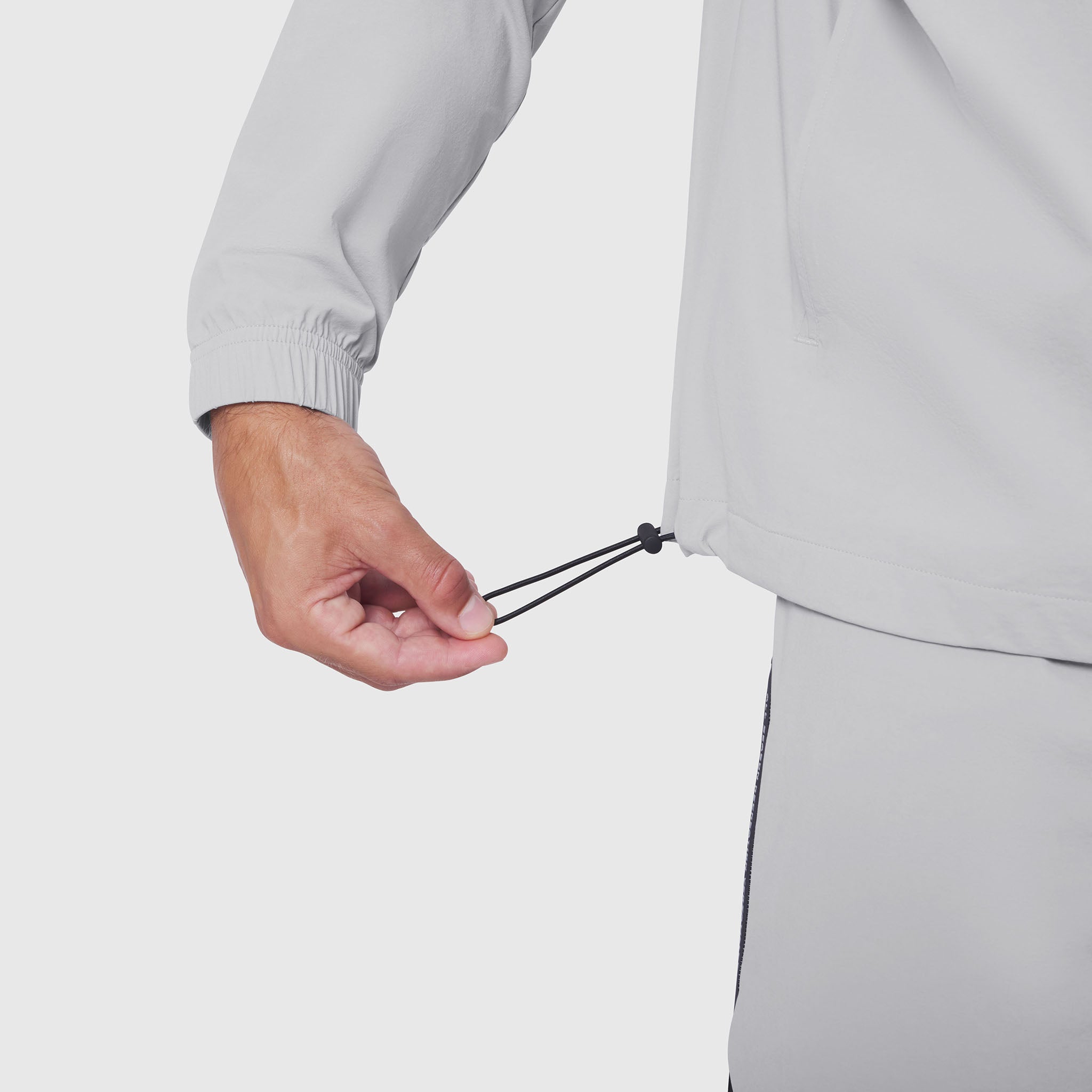 Aerotex Quarter-Zip Jacket in slate grey, model holding drawstring detail