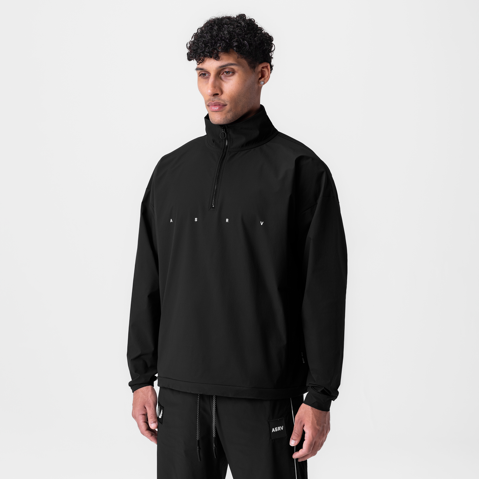 Black ripstop quarter zip jacket worn by model, front view