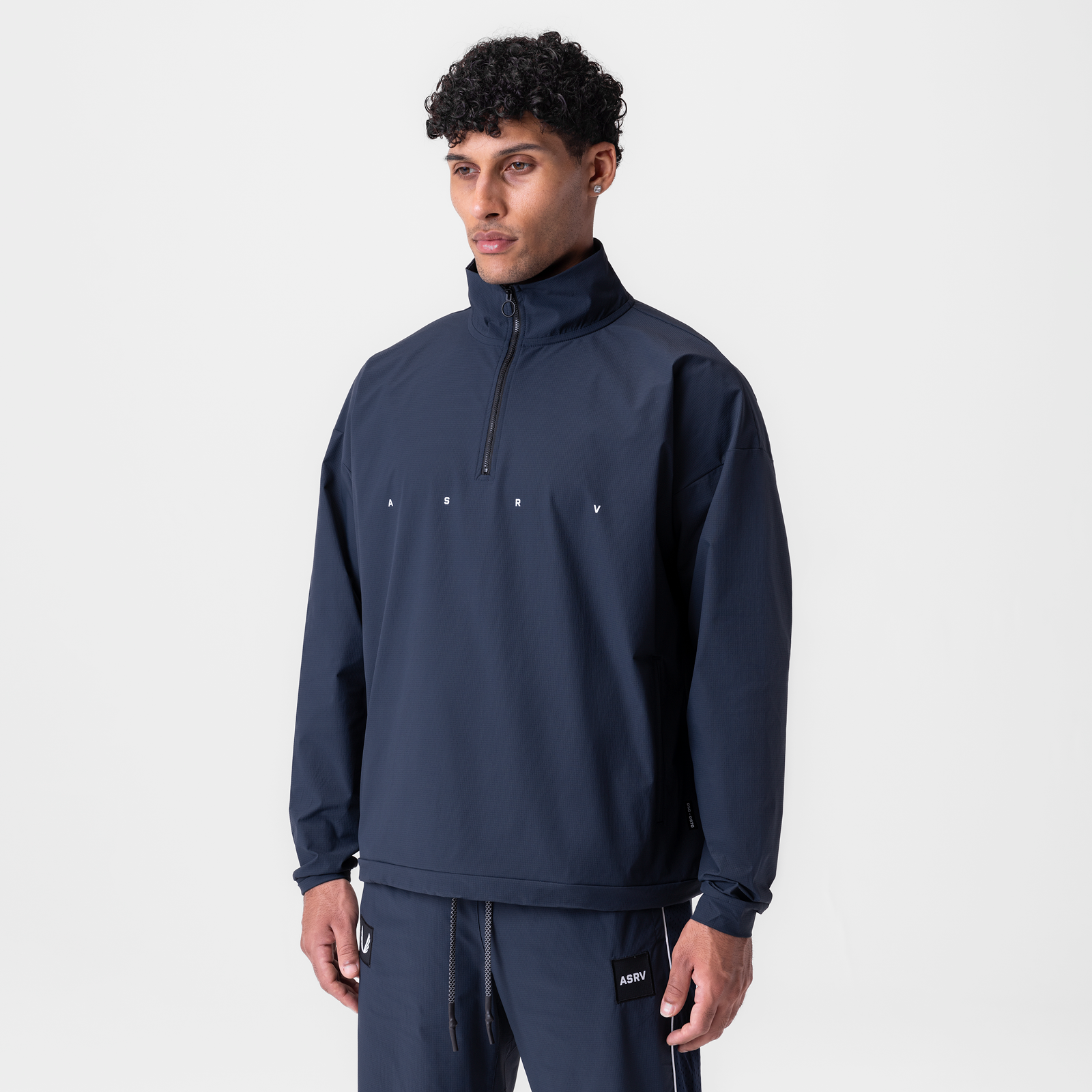 Navy ripstop quarter zip jacket worn by model, front view