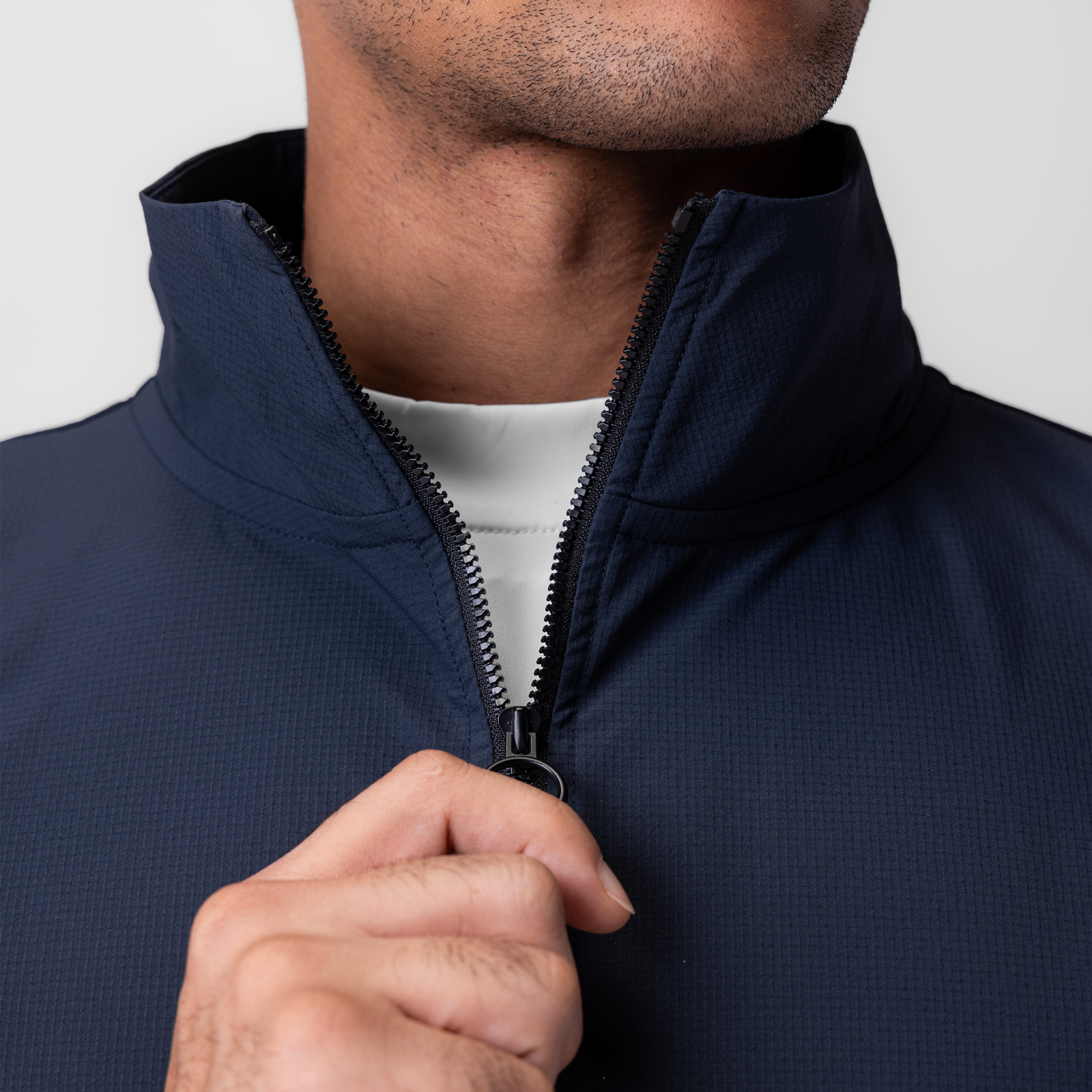 Navy ripstop quarter zip jacket on model, front view with hand on zipper