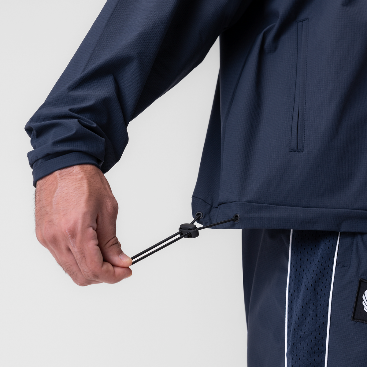 Navy ripstop quarter zip jacket worn by model, closeup of drawstring detail