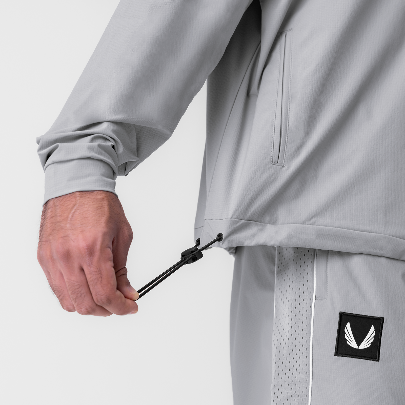 Ripstop Quarter Zip Jacket in Slate Grey, model wearing jacket with hand adjusting drawstring detail