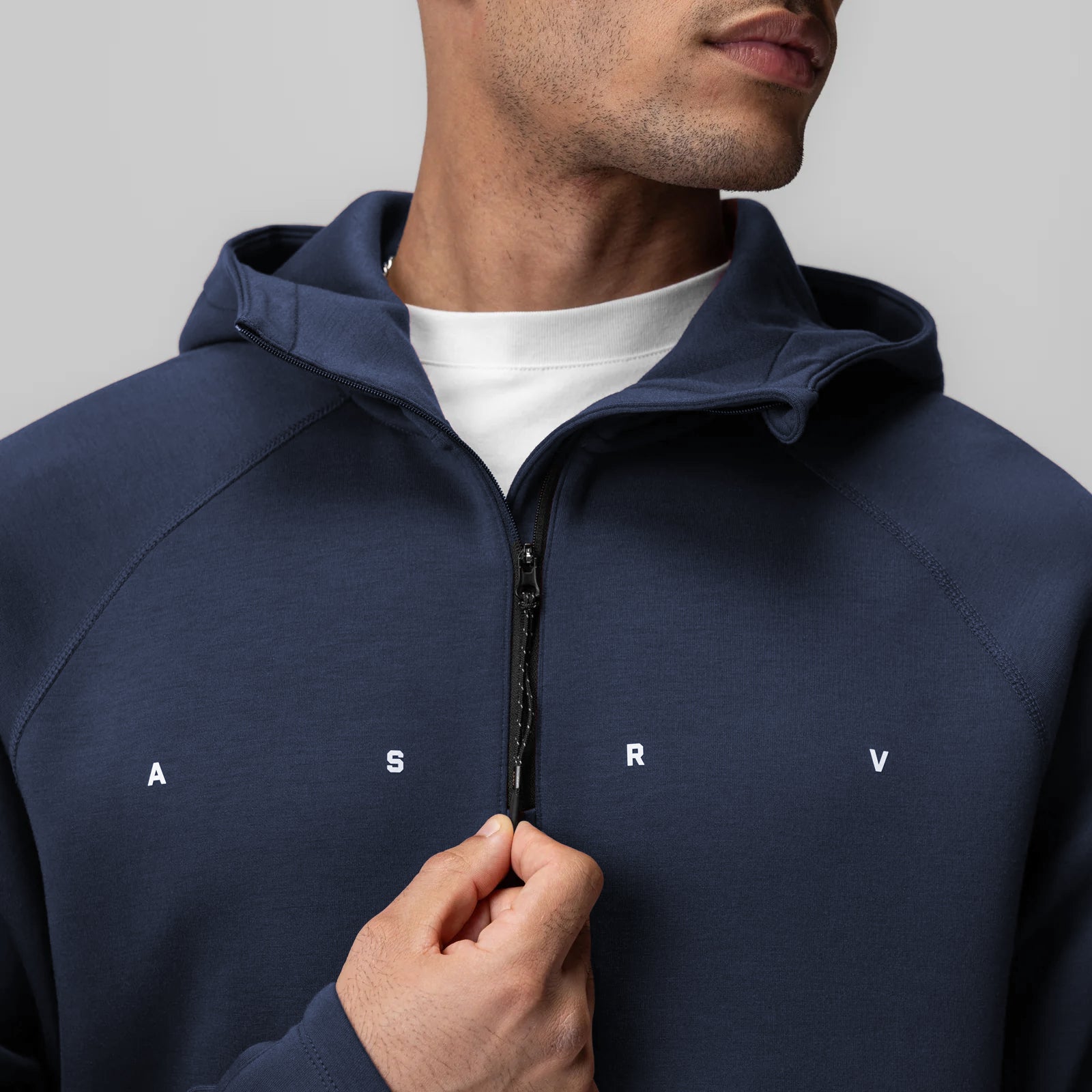 Dri-Core™ Zip Hoodie in navy worn by model, front view with hand on zipper