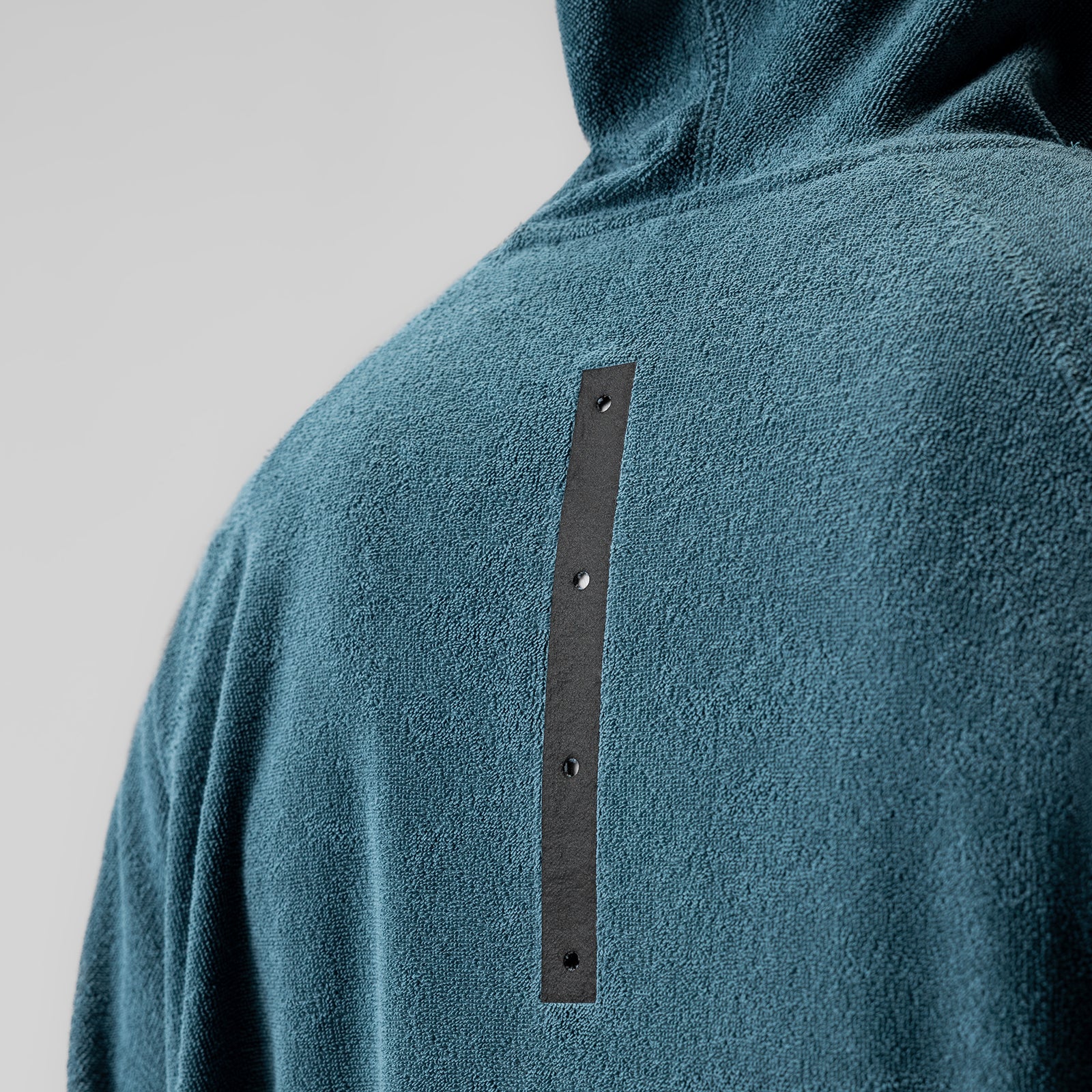 Towel Terry Reversible Hoodie in storm blue worn by model, back detail view showing leather accent strip