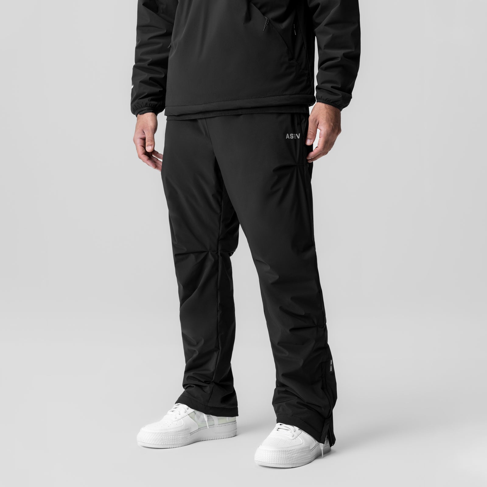 Aerotex™ PrimaLoft® Warm-Up Pant in black, worn with white sneakers, front view