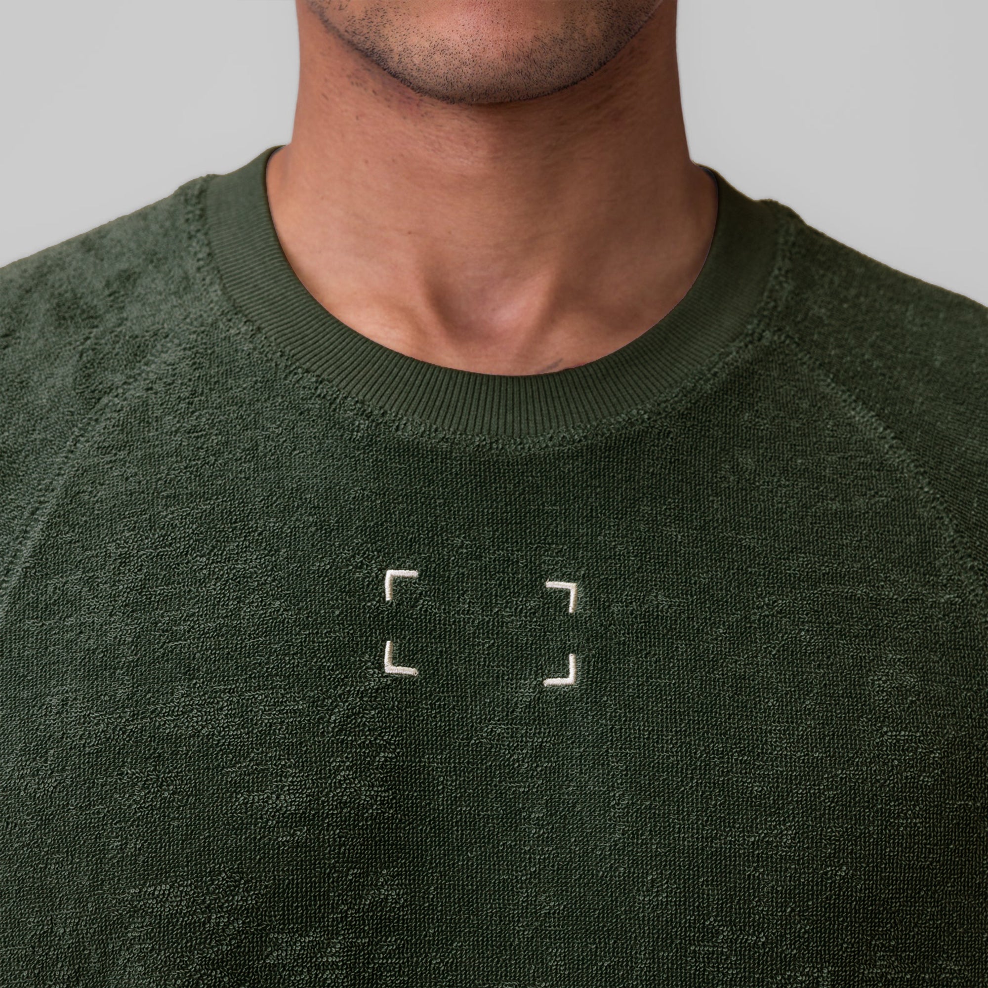 Towel Terry Cutoff sweatshirt in olive, worn by model, front view with chest graphic detail